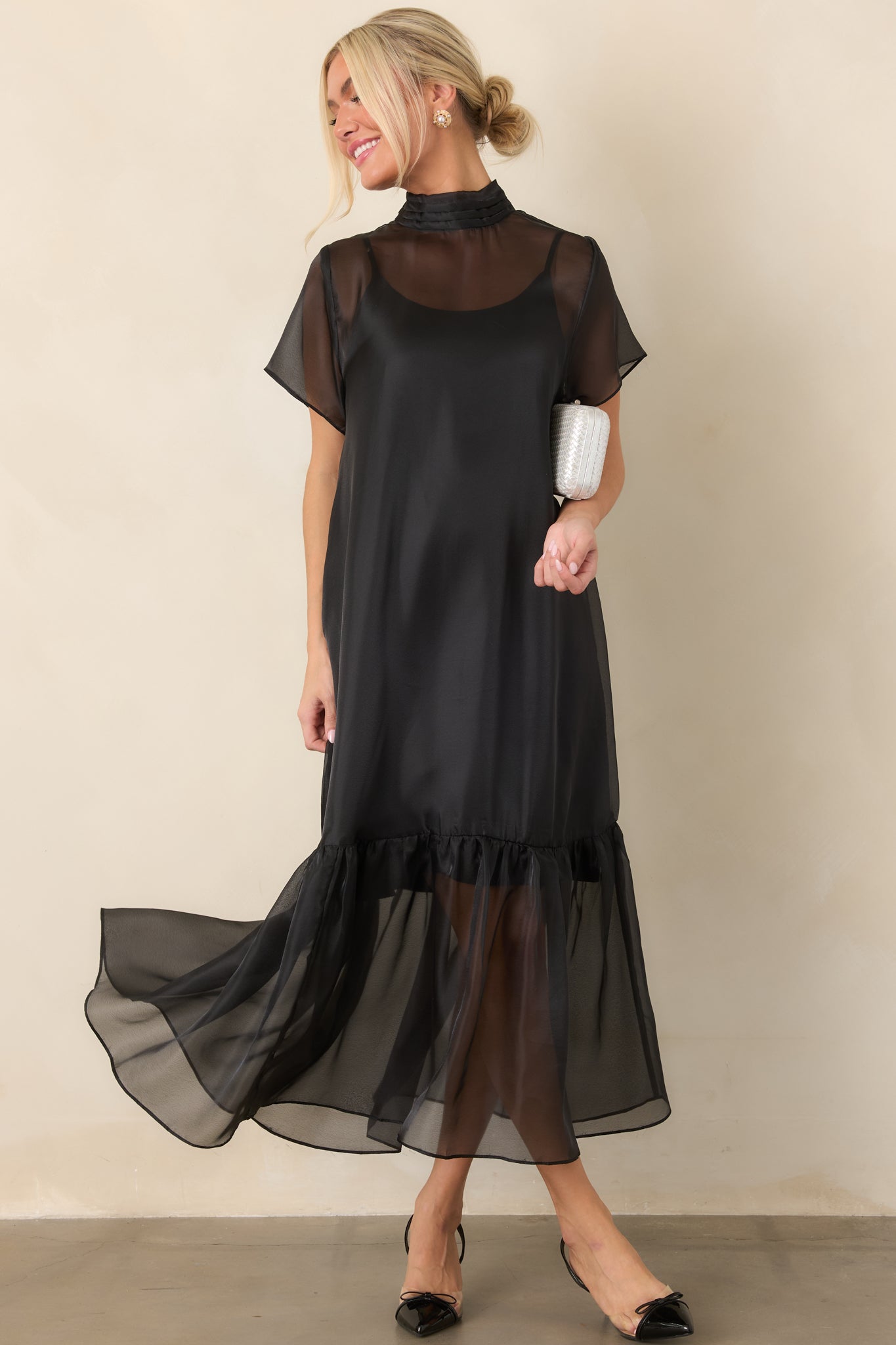 Elegant organza dress showcasing a translucent overlay, coordinating lining, short sleeves, and a softly gathered maxi-length skirt.