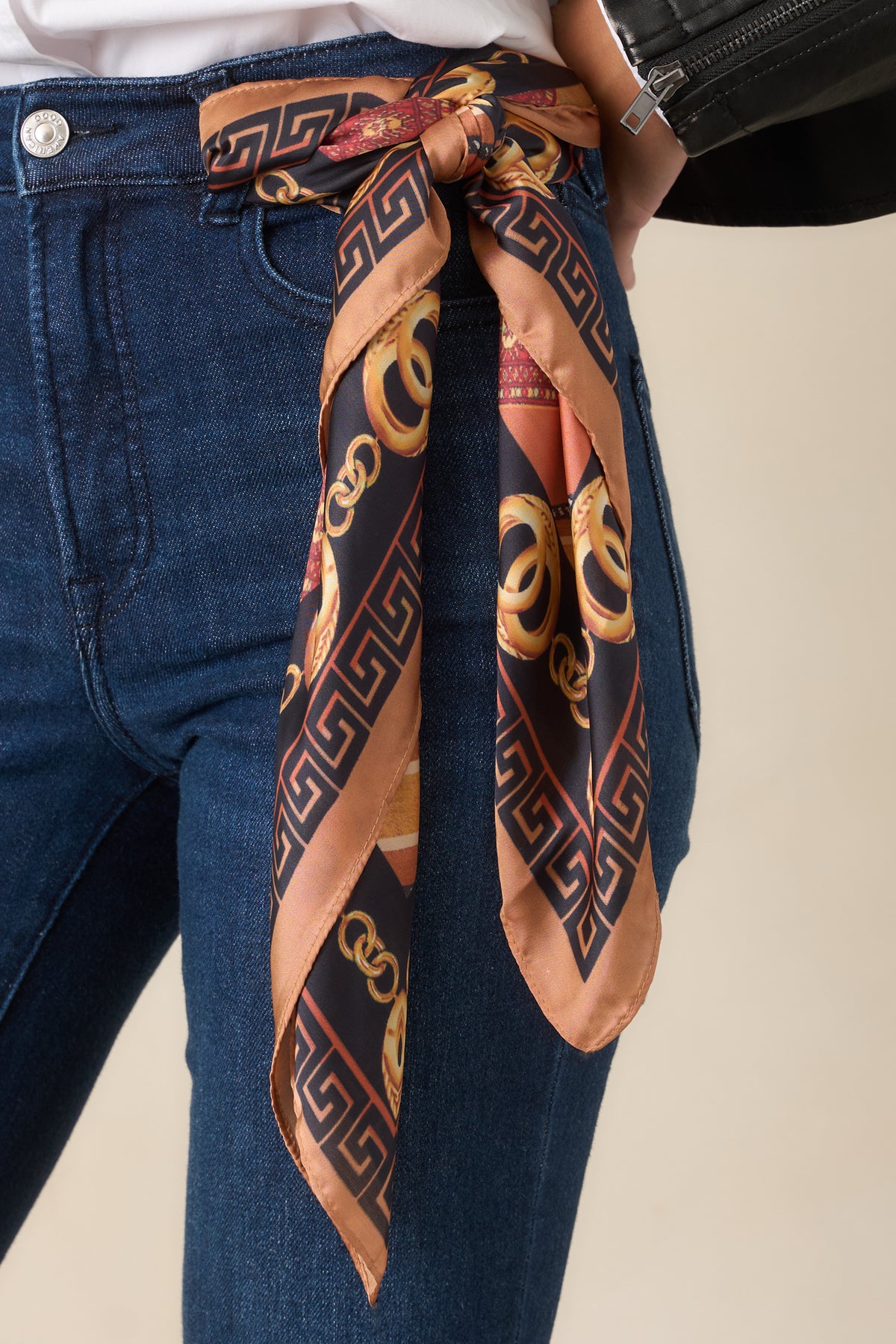 Ornate square scarf showcasing golden chain designs, patterned stripes, and a decorative Greek key border with warm camel and black accents.