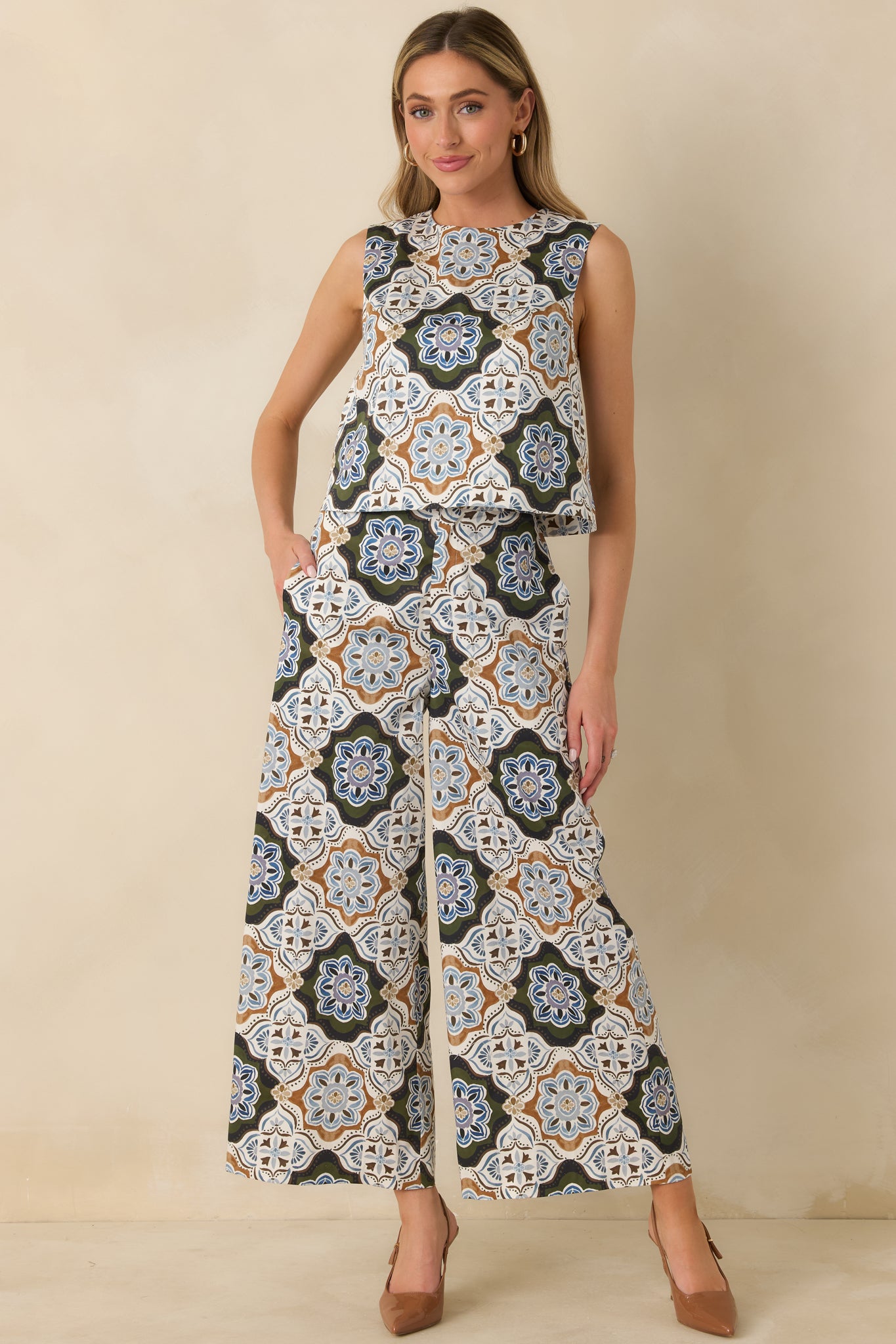 Ornate medallion print pants featuring a flattering high-rise waist, front button closure, and roomy side pockets.
