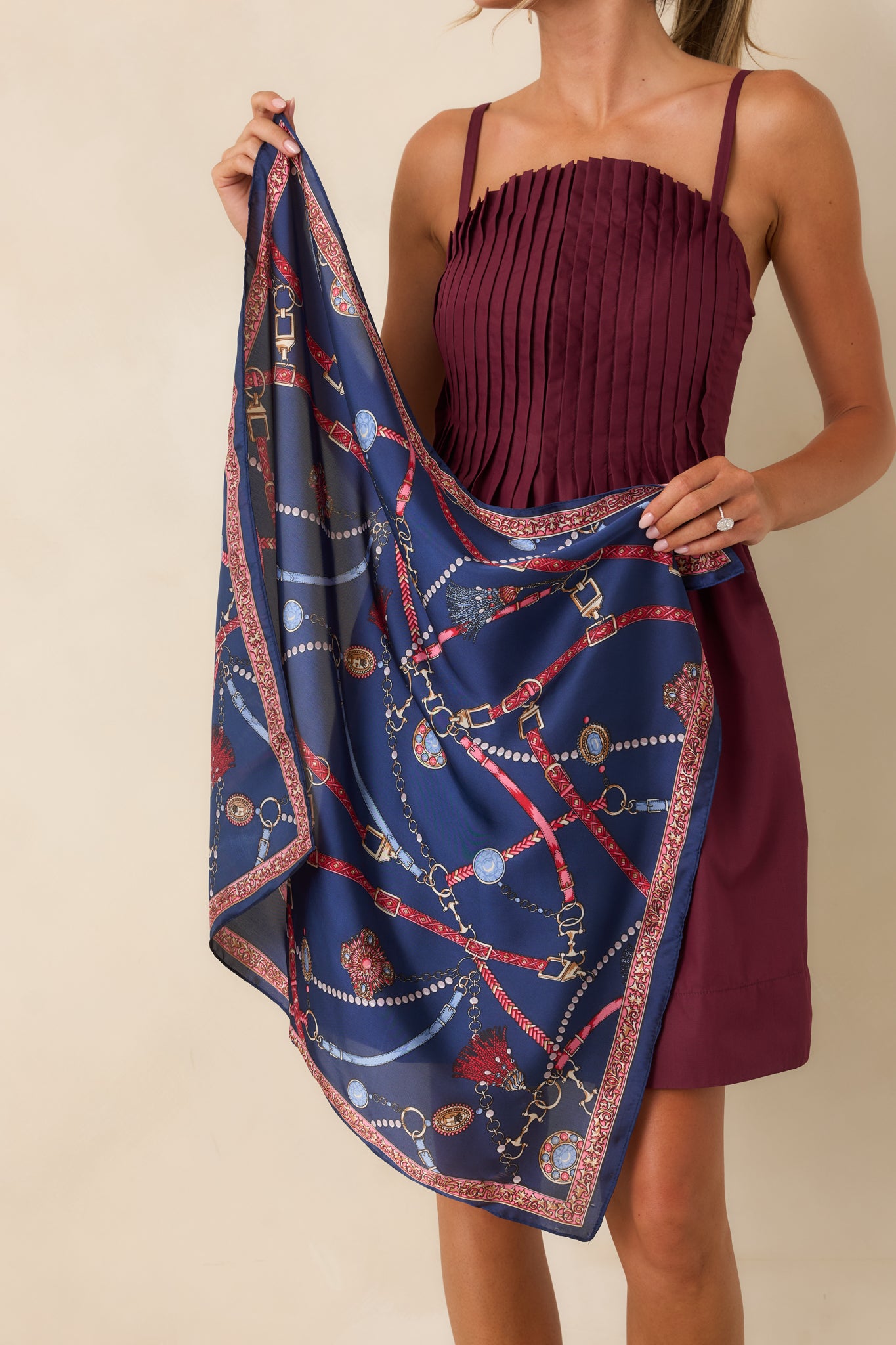 Red, light blue, and gold accents highlight the ornate buckle and medallion design of this scarf.