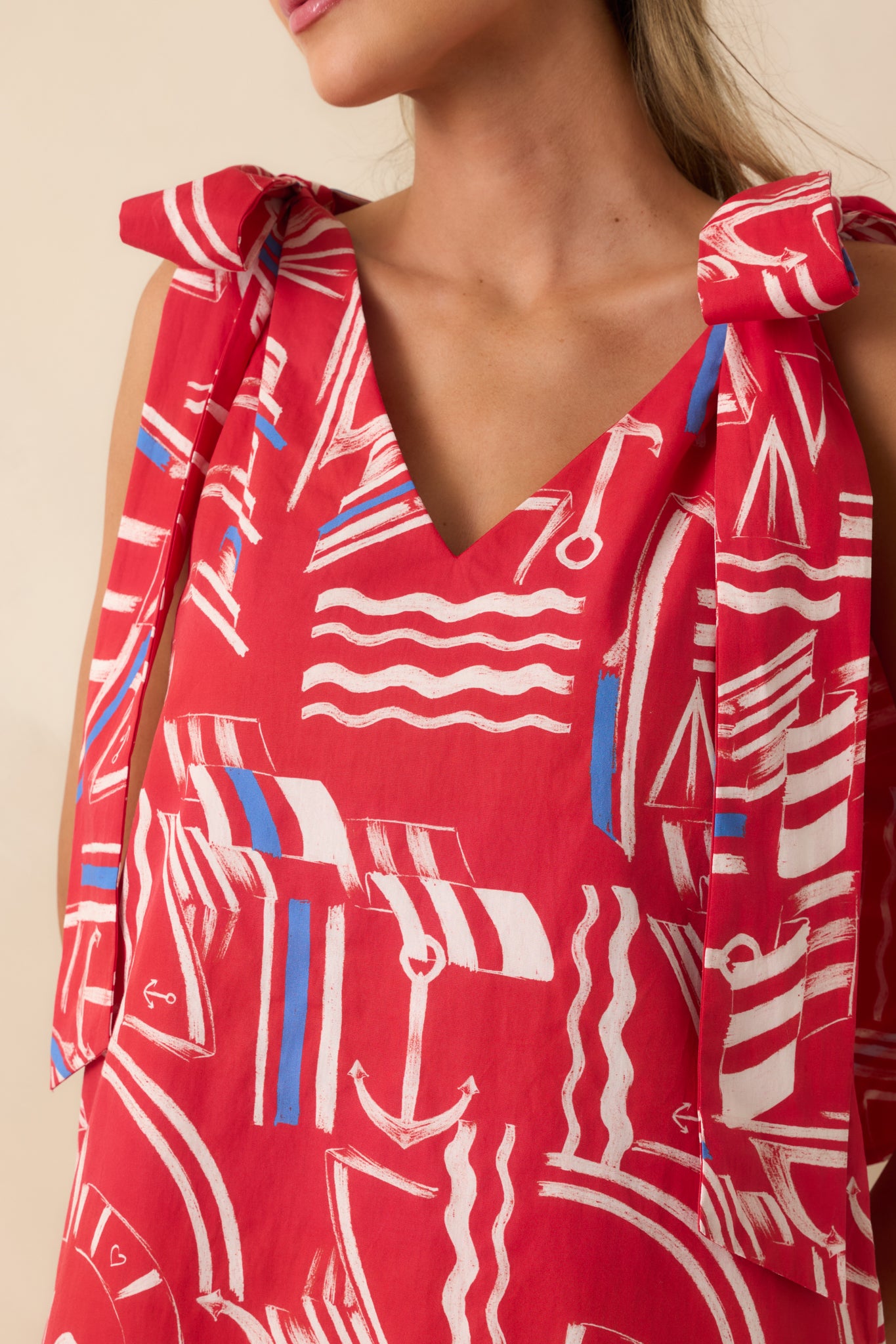 Close-up of the oversized self-tie bow straps and vibrant yacht club print on the cotton maxi dress.