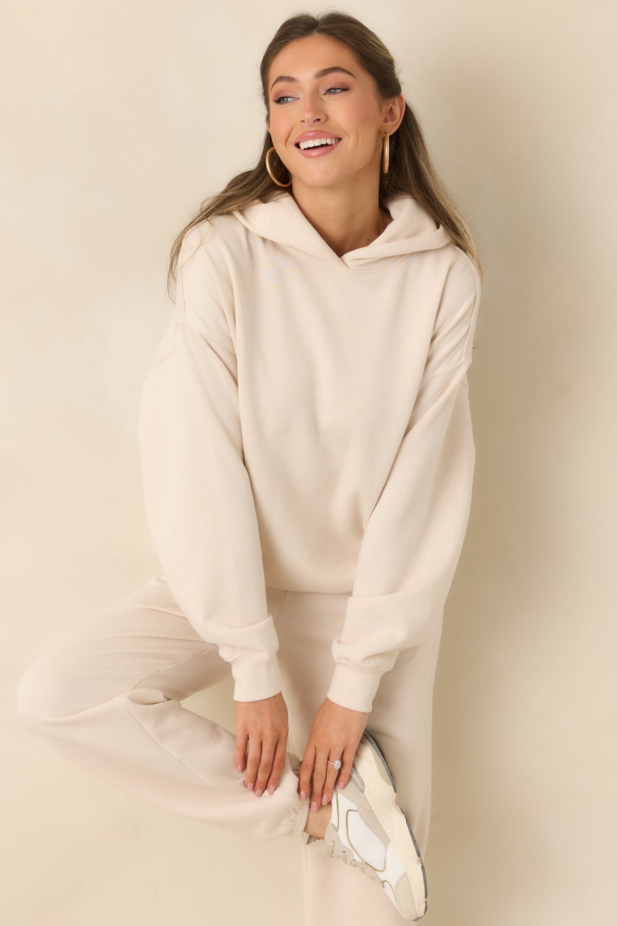 Oversized cream hoodie with a roomy hood, long sleeves, and ribbed hem.