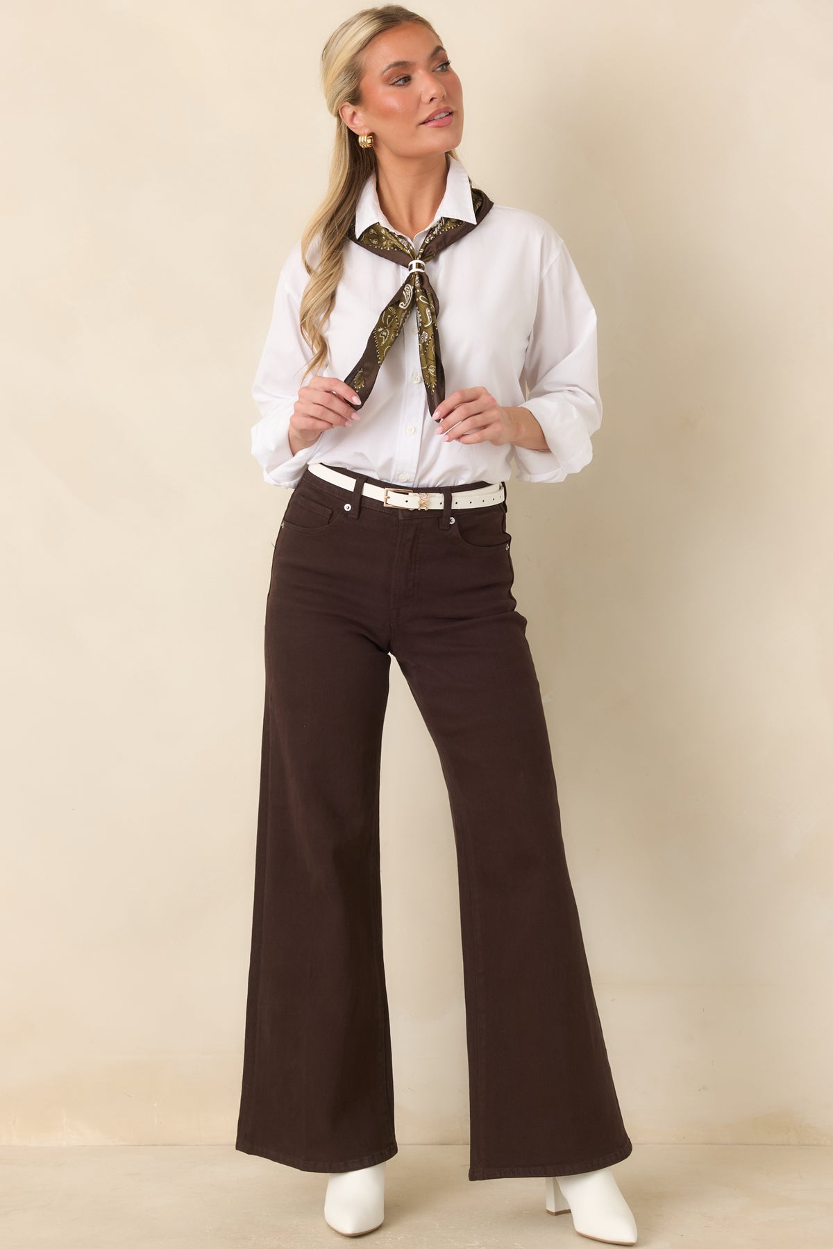 Oversized white cotton poplin button-up shirt with a classic collar, full front button closure, and curved hemline.
