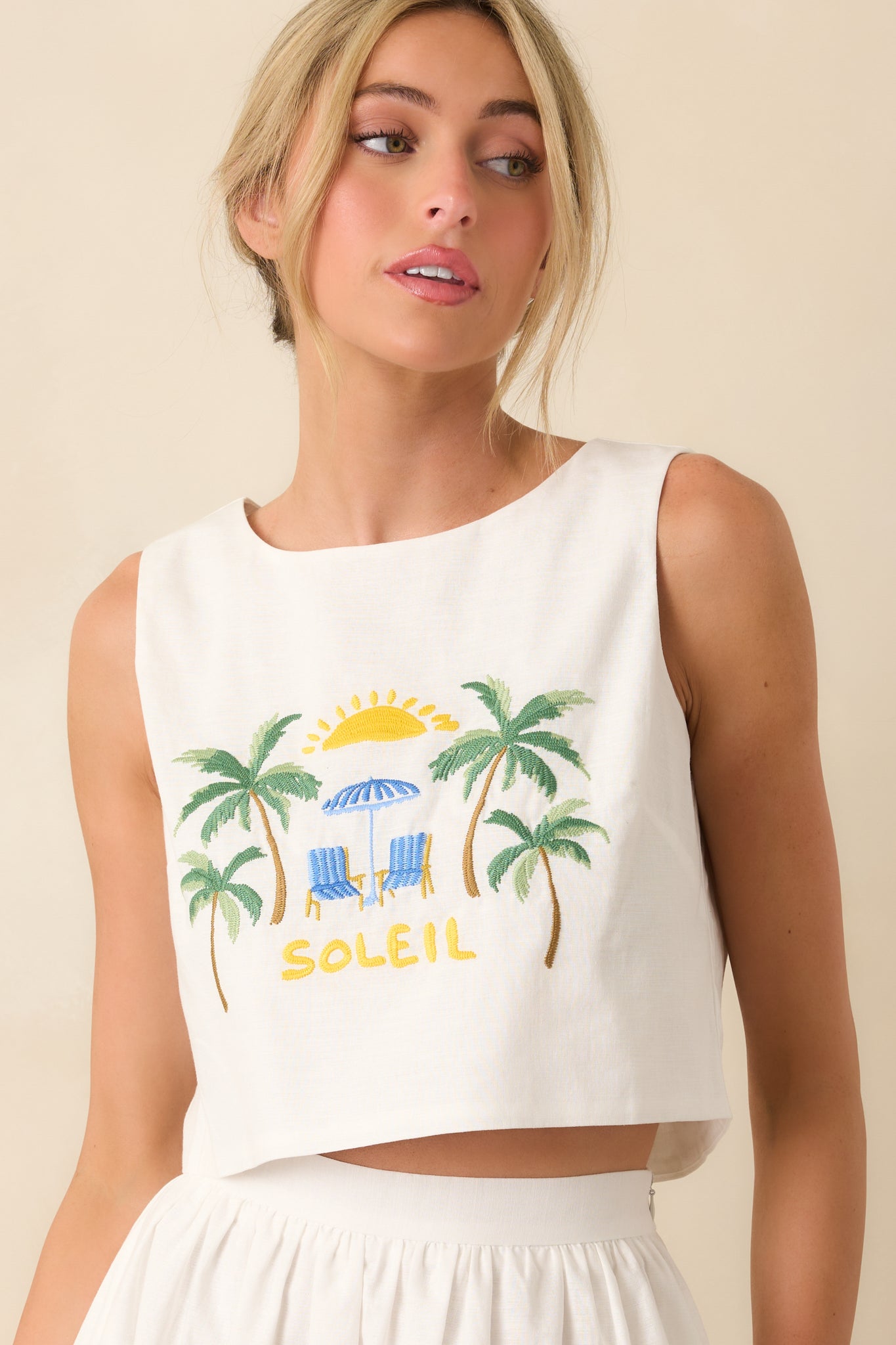 Detailed look at high neckline and structured shape on cropped white top.
