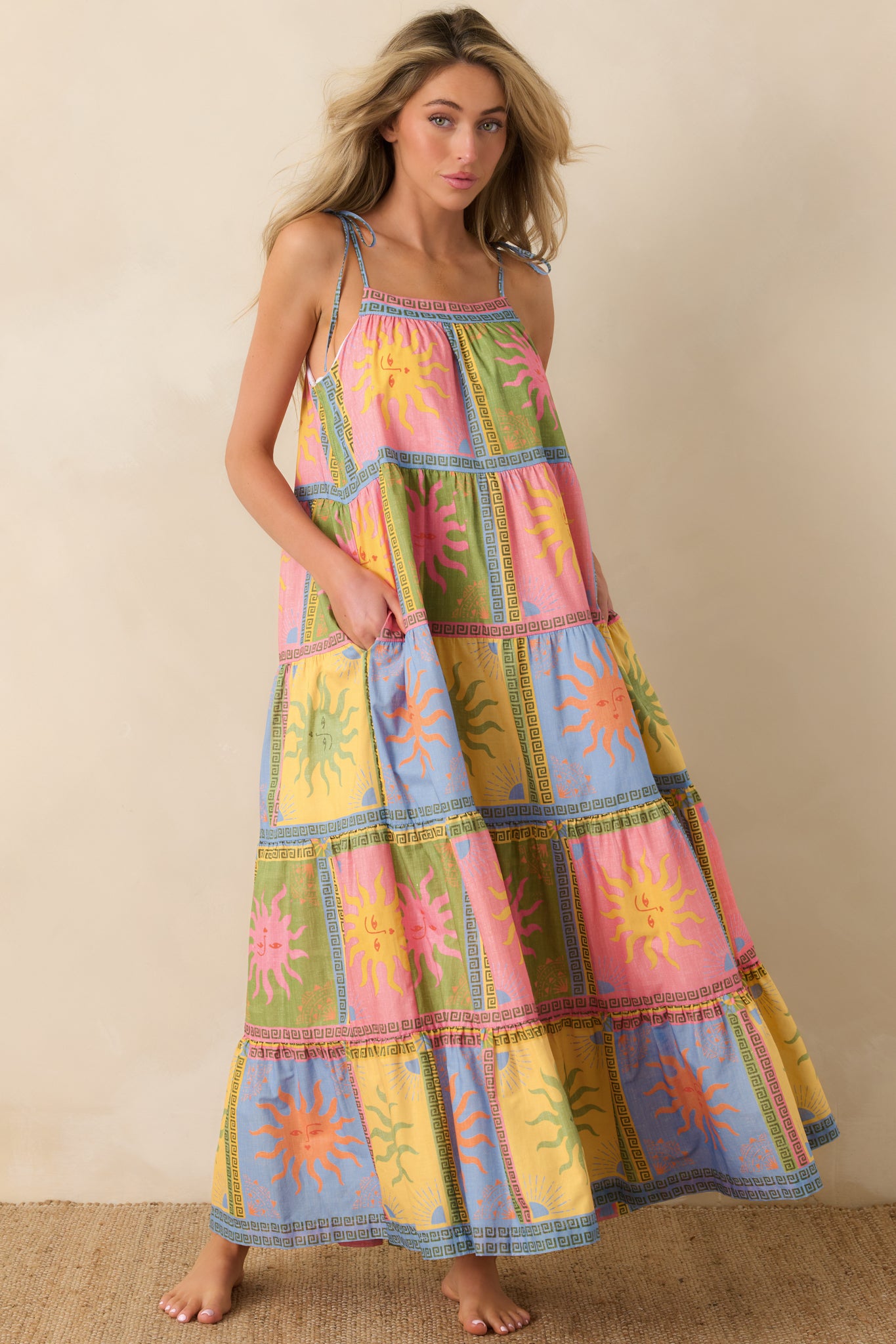 Colorful patchwork maxi dress featuring sun motifs and geometric borders, designed with a flowing tiered silhouette in lightweight cotton voile.