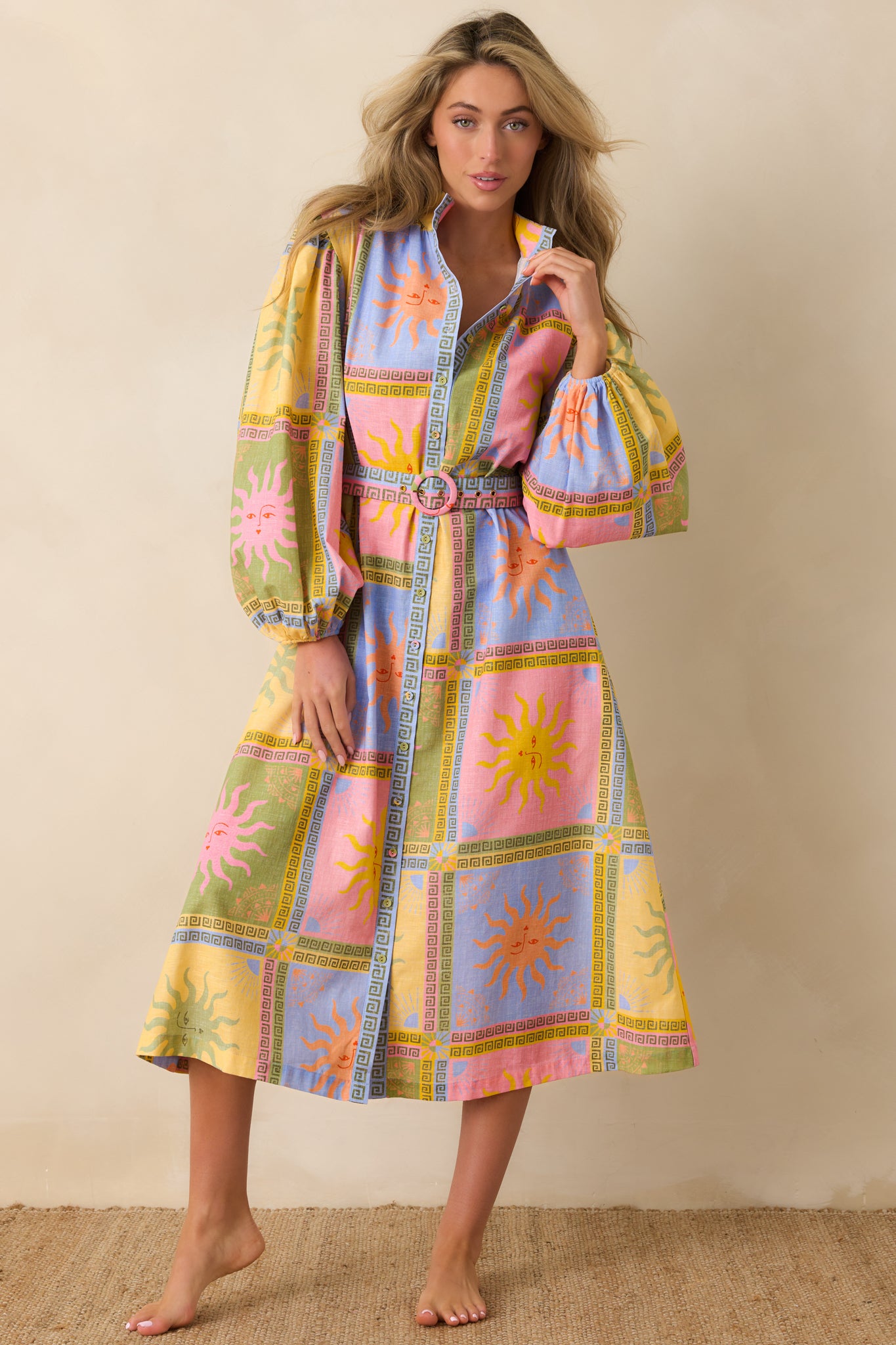 Sun-inspired print midi dress showcasing a structured bodice with a button-front design, long sleeves with gentle volume, and a softly flowing skirt for graceful movement.