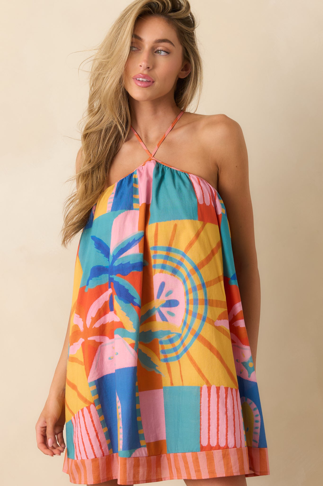 Front detail view of the relaxed bodice and adjustable strap construction on the tropical print mini dress.