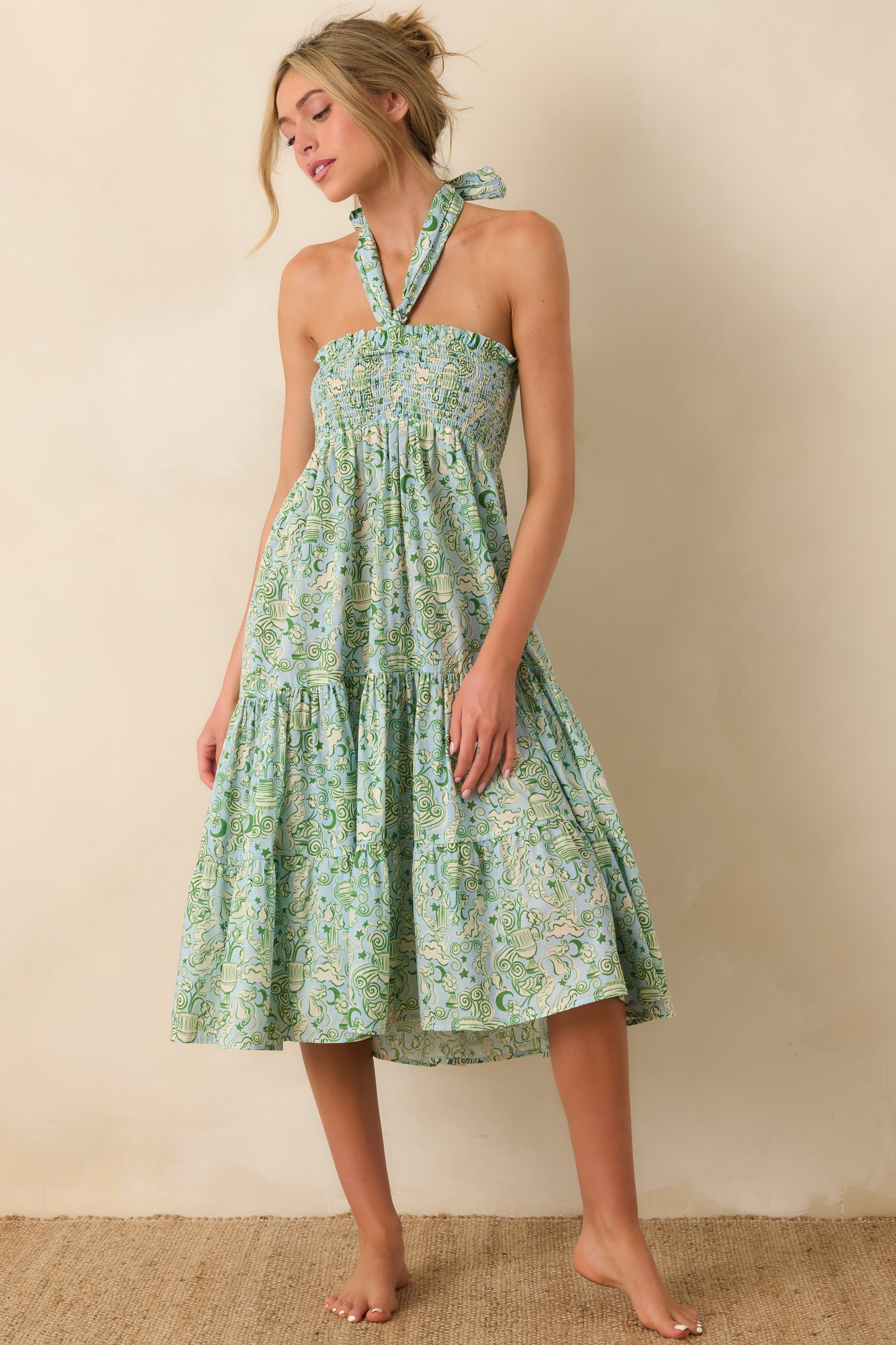Woman wearing a green mermaid print strapless dress against a beige background