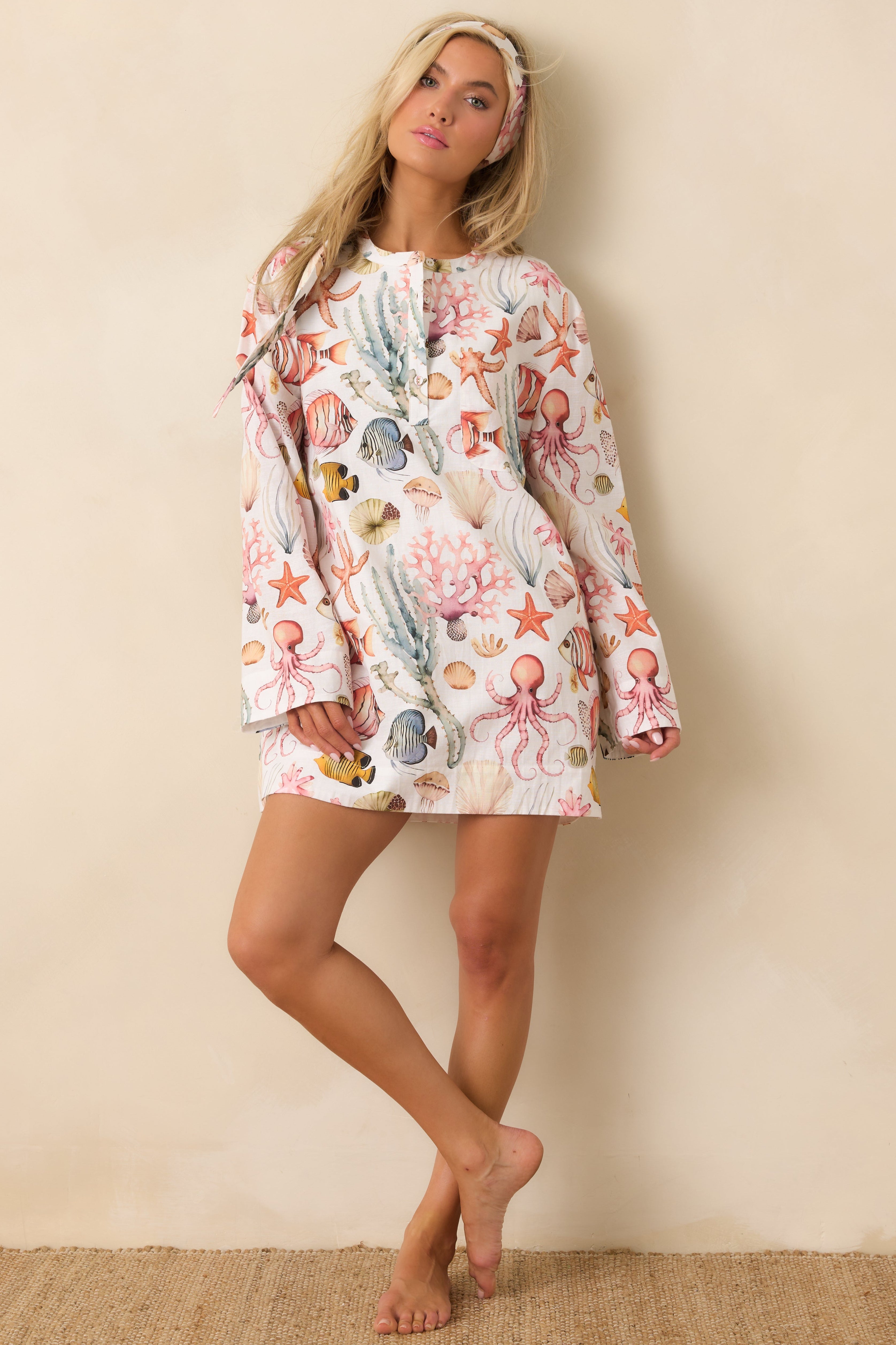 Woman wearing a tunic dress cover up with sea creatures painted on it