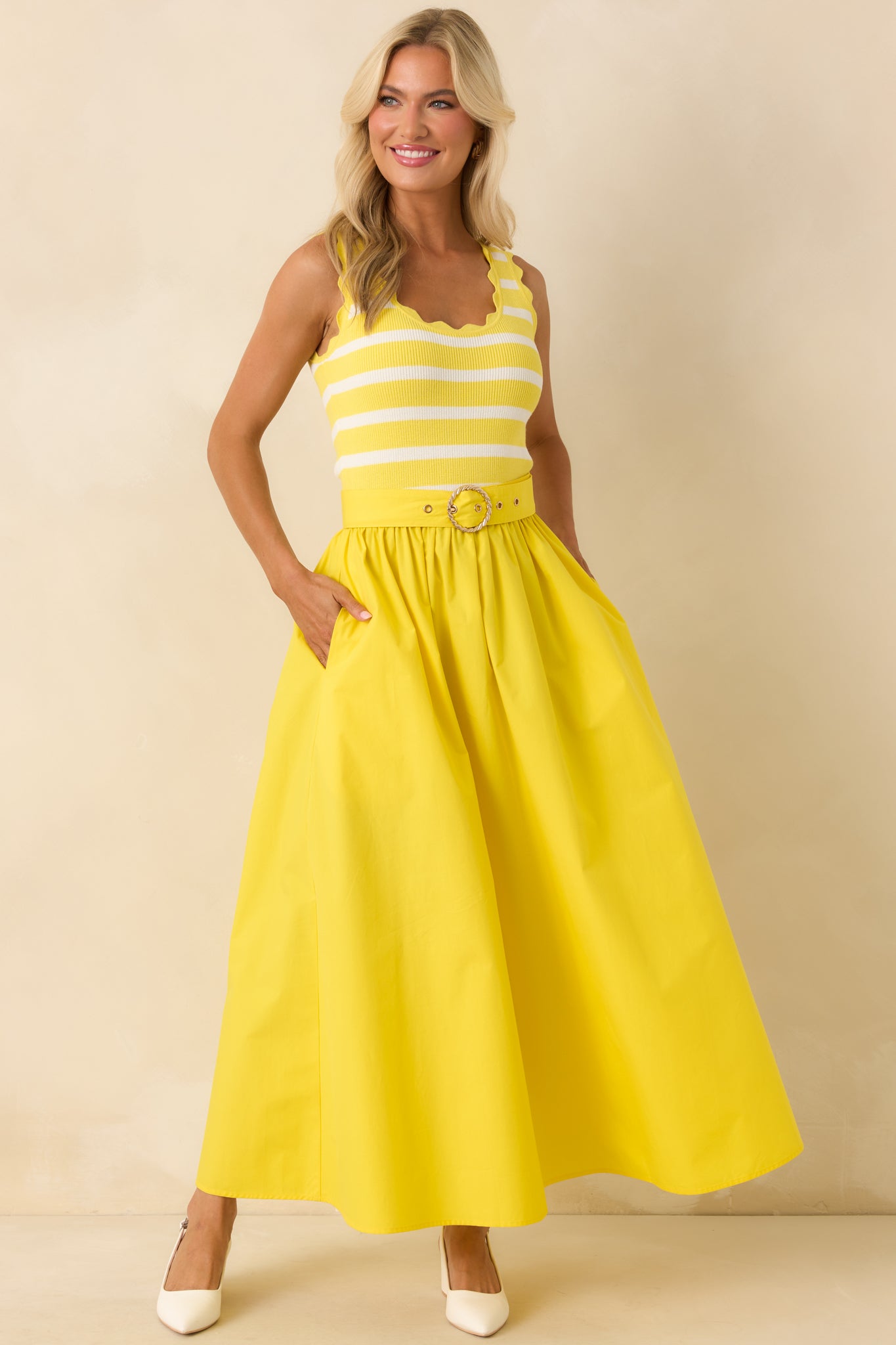 Yellow midi dress with striped knit bodice, scalloped edge detailing, and softly gathered skirt with pockets.