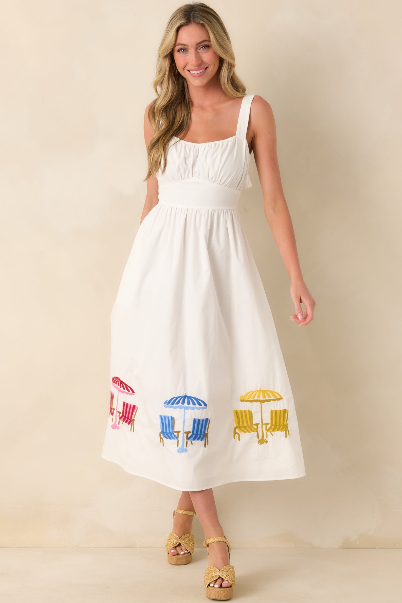 Midi dress featuring a square neckline, softly gathered bodice, and embroidered beach umbrella details along the hem.