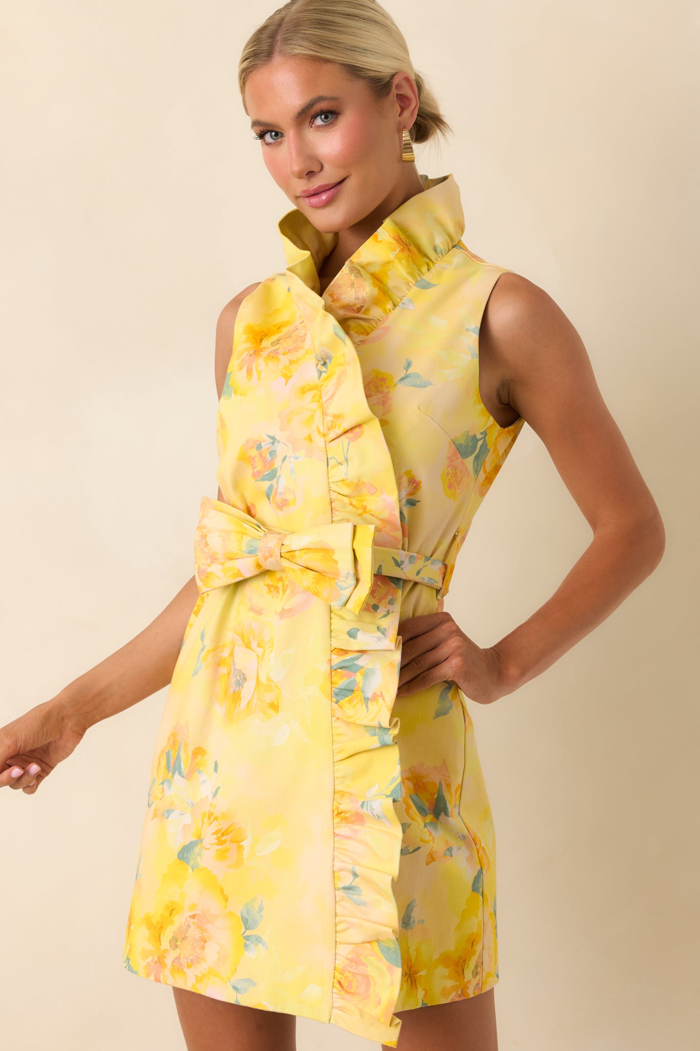 Cropped detail of yellow multi floral print with ruffle trim along the faux wrap hemline.