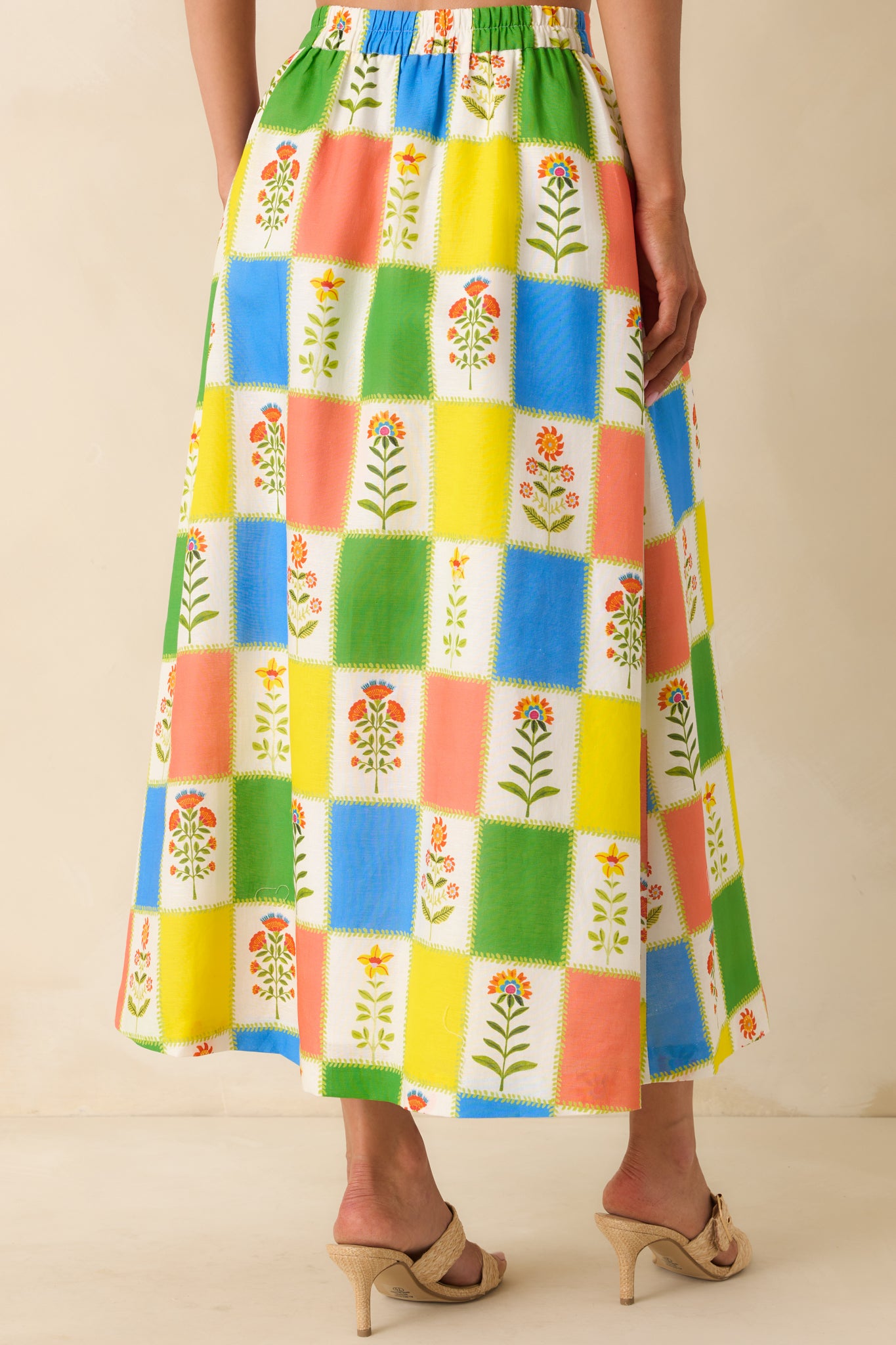 Rear view of the skirt highlighting the continuous patchwork print, relaxed flow through the hem, and comfortable waist placement with an easy drape.