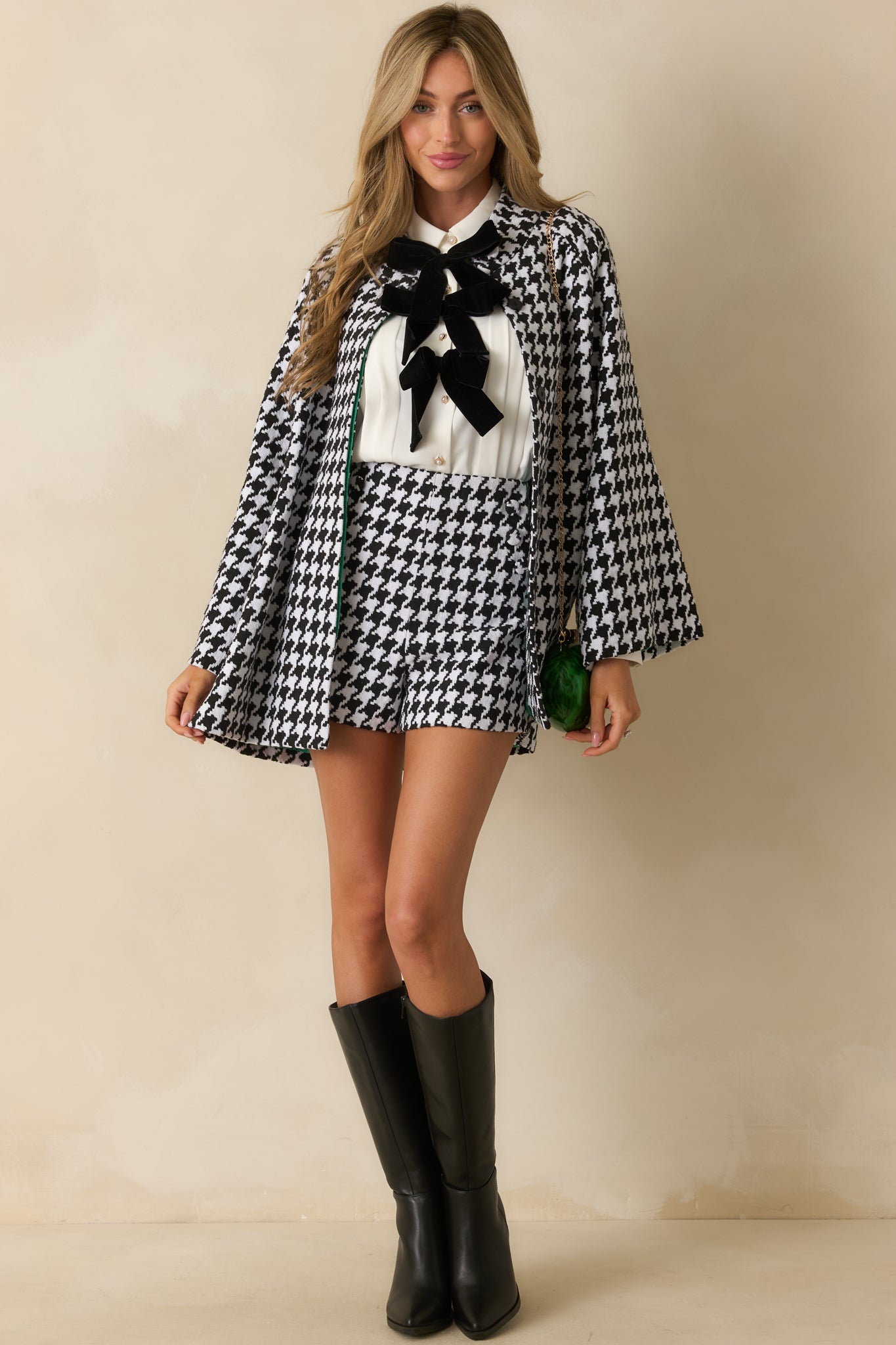 Black-and-white houndstooth coat with a collared neckline, long sleeves, hip-length fit, and functional front buttons.