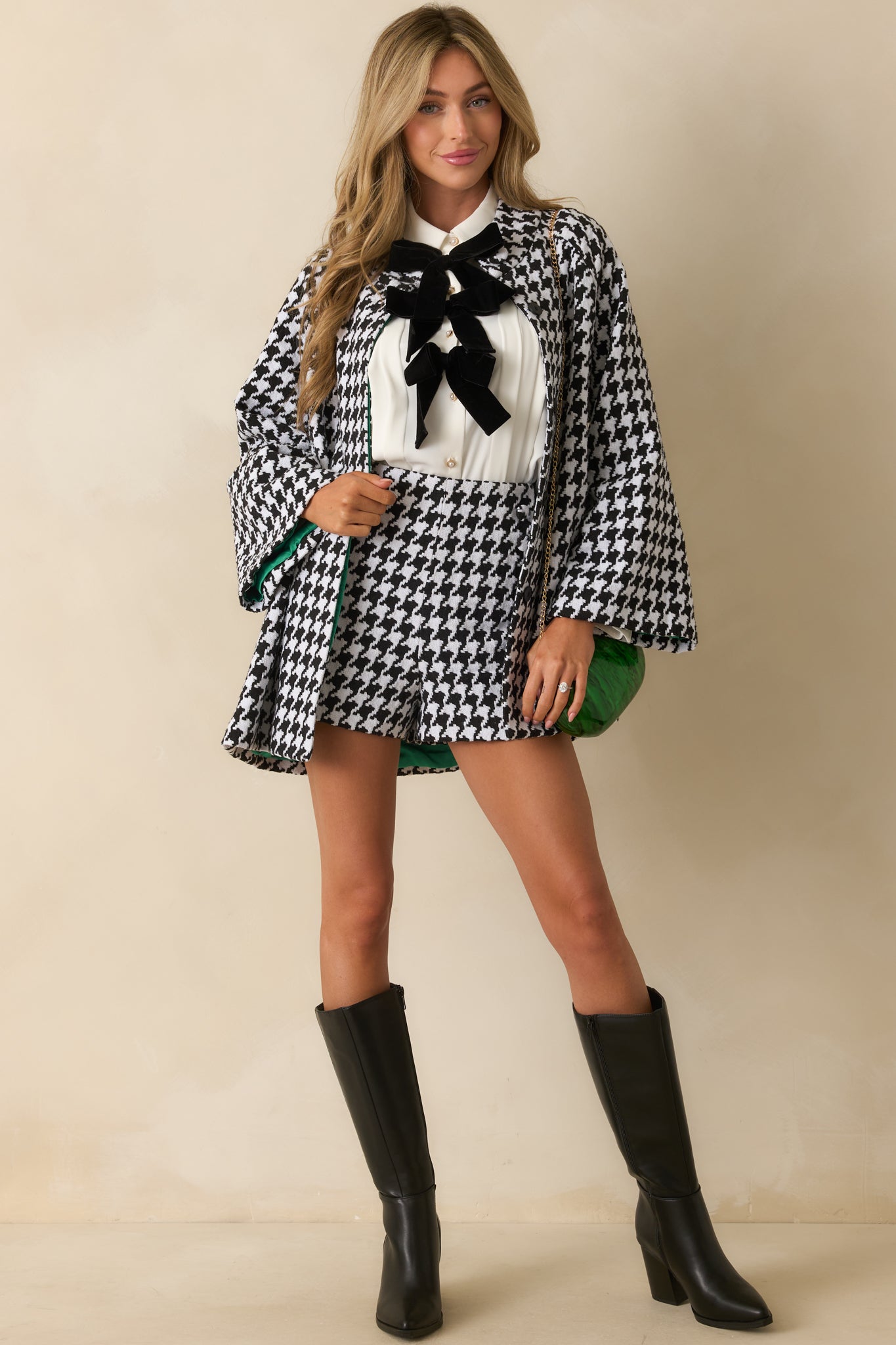 Black-and-white woven coat showcasing functional side pockets, long sleeves, and a tailored hip-length fit.