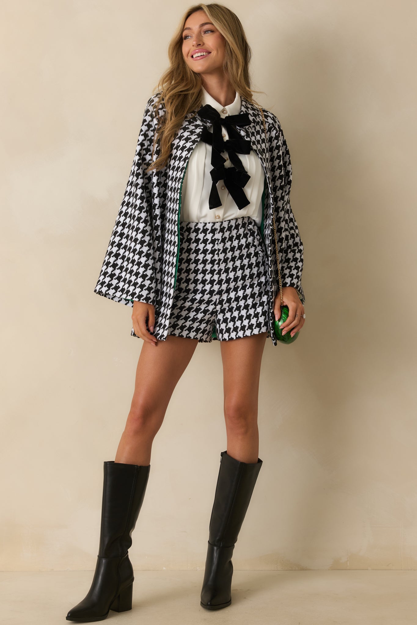 Black-and-white houndstooth coat with long sleeves, button-front closure, and functional side pockets.