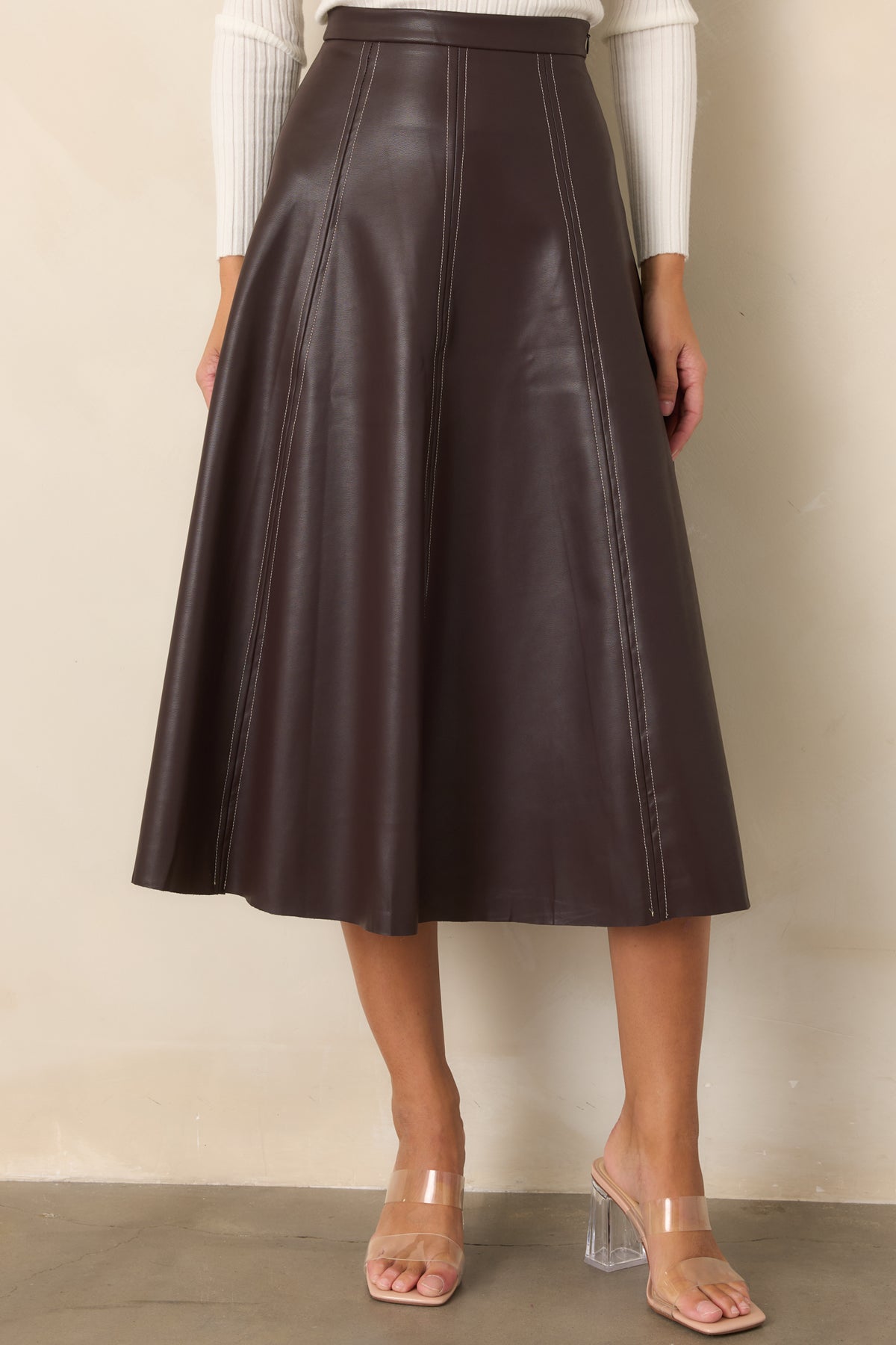 Paneled faux leather skirt showcasing the smooth finish and contrasting stitched seams.