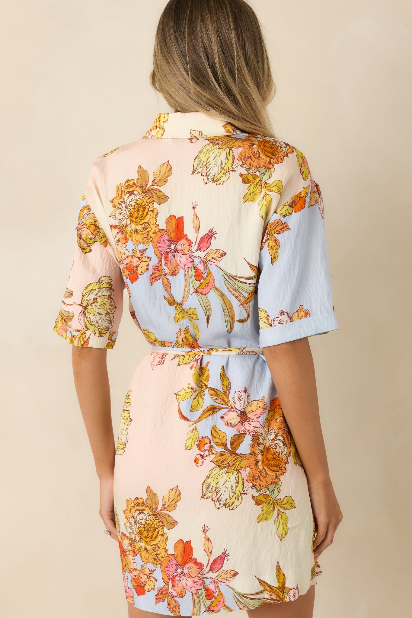 Back of the pastel floral mini dress featuring a relaxed silhouette and coordinating removable self-tie belt.