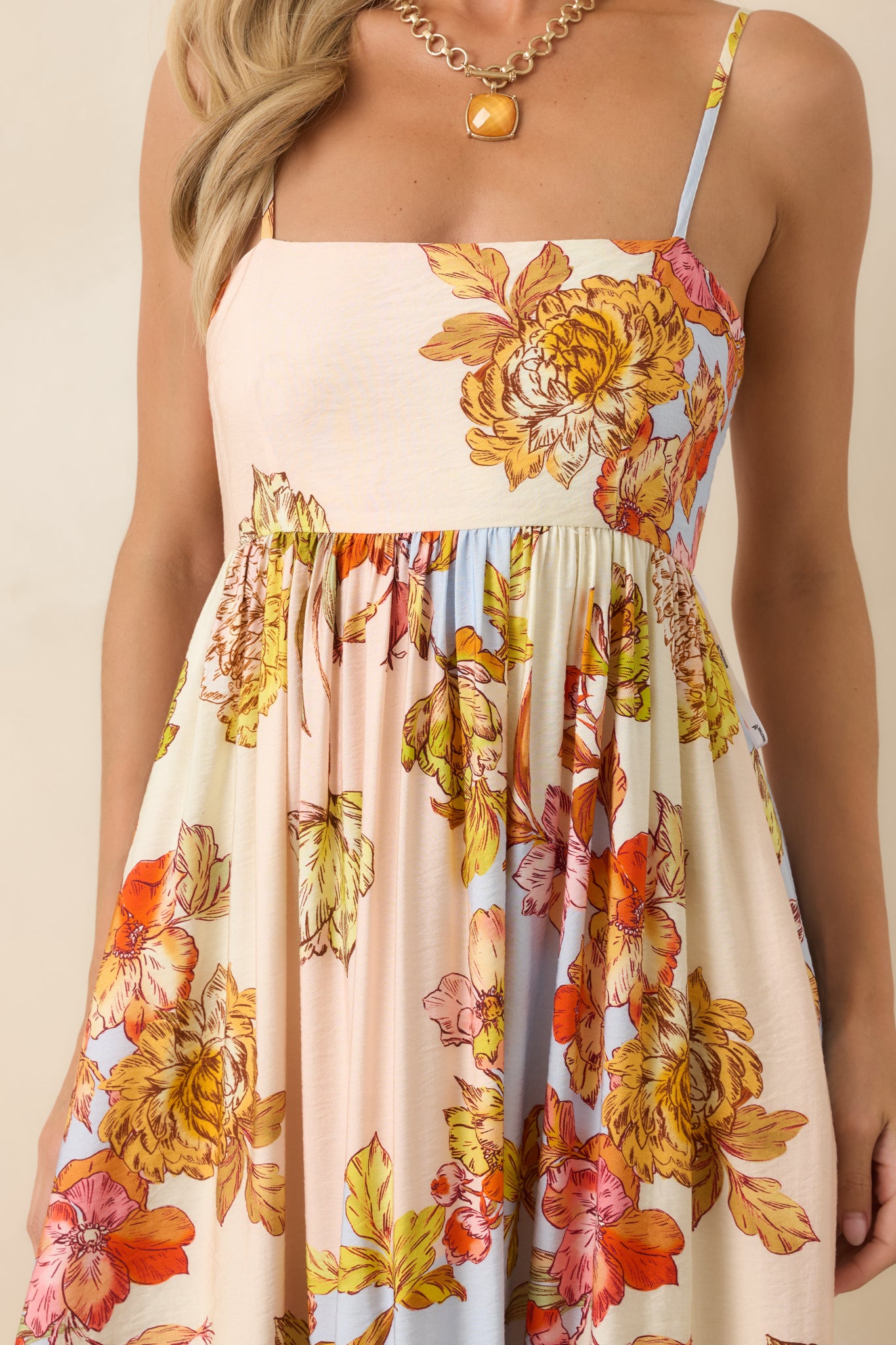 Close-up of the gathered bodice showcasing the pastel floral print and adjustable spaghetti strap details.