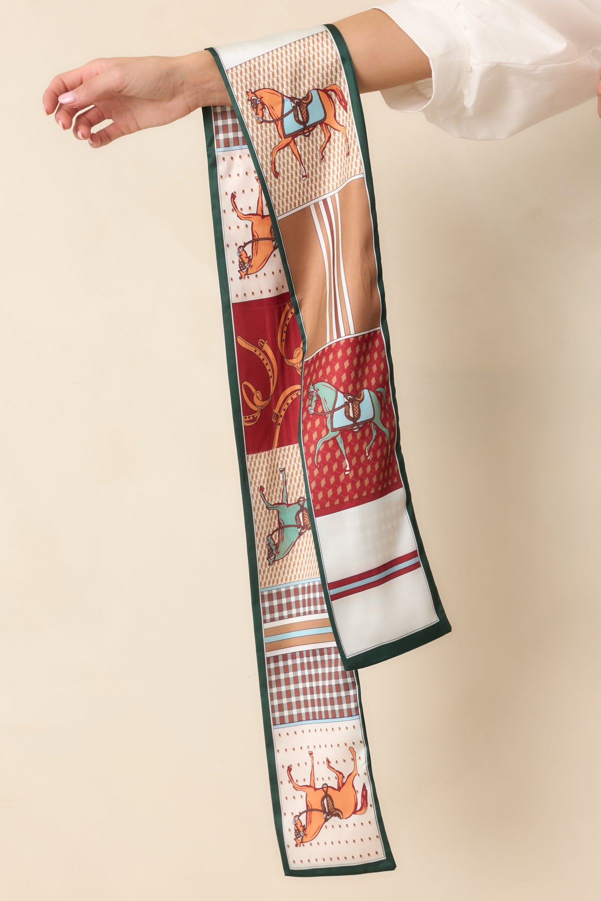 Patchwork-inspired scarf featuring horse motifs, classic checks, and geometric patterns in burgundy, rust, camel, and ivory.