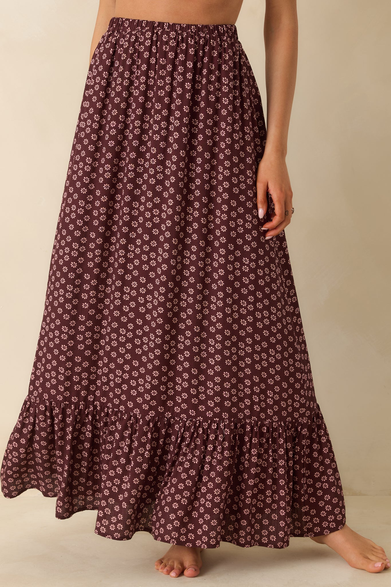 Patterned burgundy maxi skirt highlighting its smooth waistband and fluttery flow.