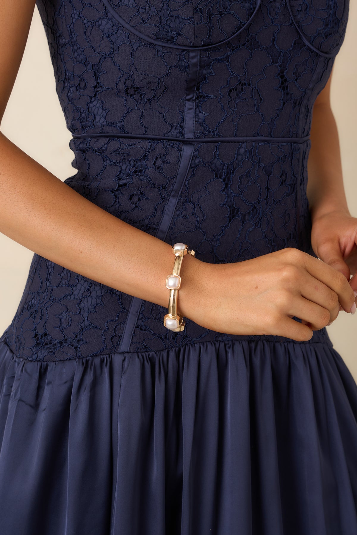 Structured bracelet featuring creamy pearl accents in rounded square settings along a slender band.
