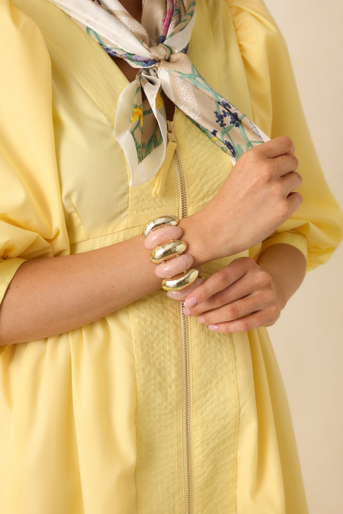 Cropped view of pink and gold statement bracelet with alternating beads on double stretch bands.