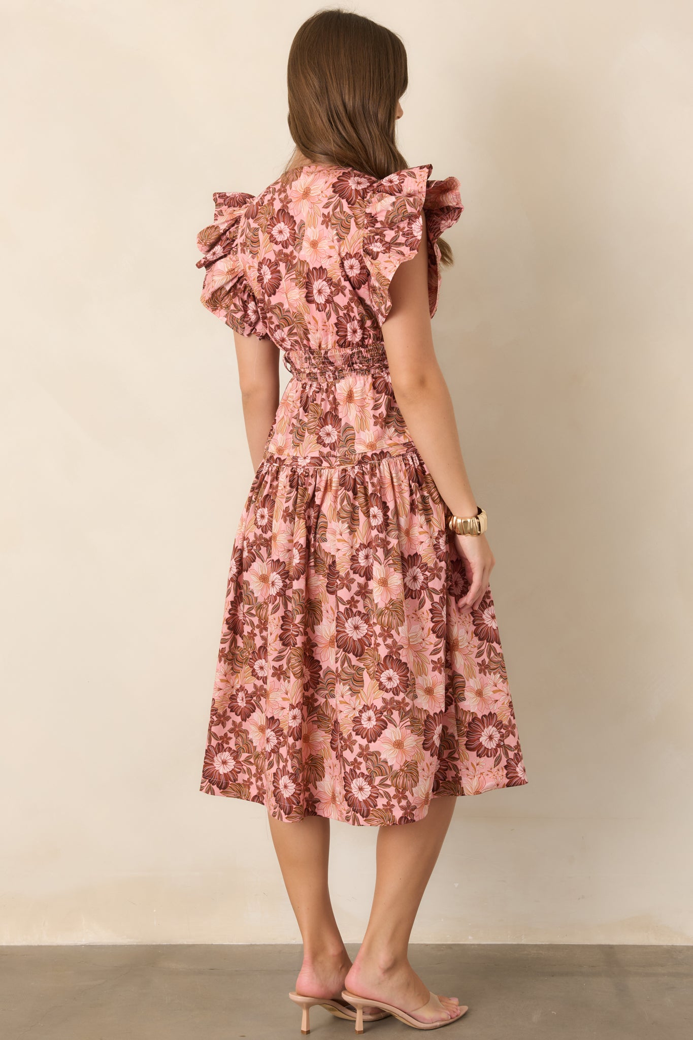 Rear view of the pastel pink and rich brown floral dress, showing the flowing gathered skirt, defined waist, and overall silhouette.