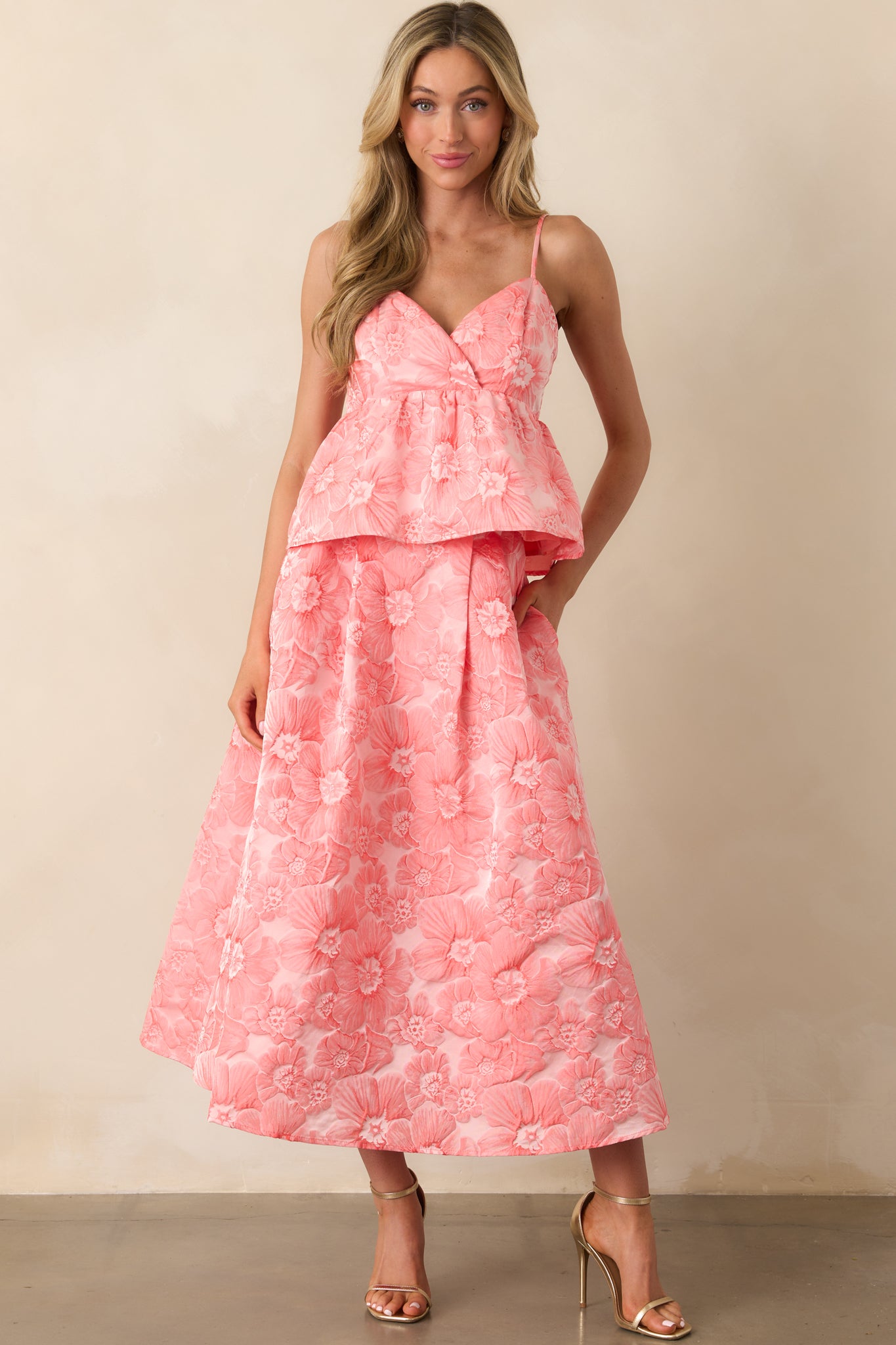 Pink coral midi skirt with a high waisted fit and floral pattern flowing through the length of the fabric.