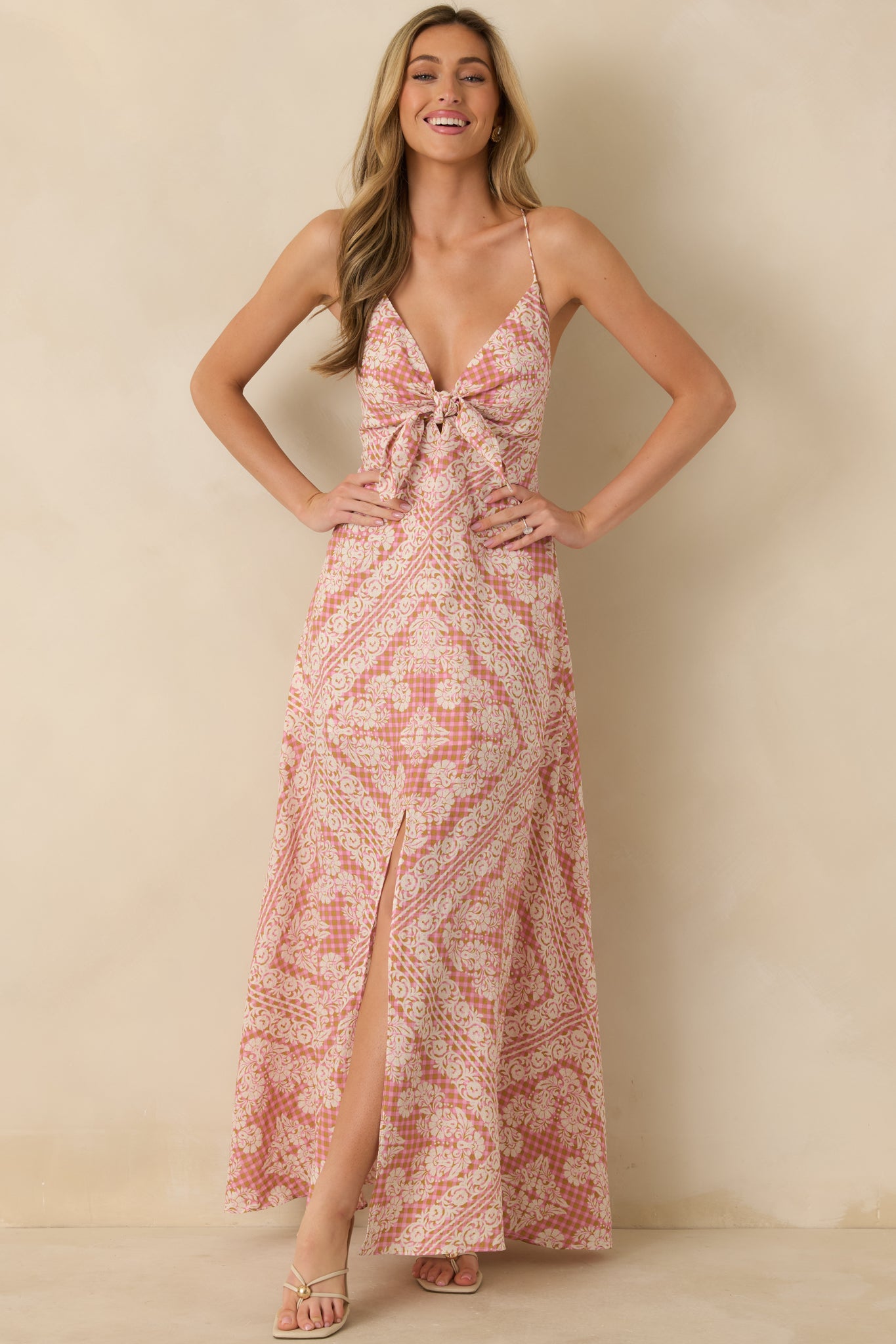 Pink dress featuring a V-neckline with tie-front detail and geometric floral print throughout.