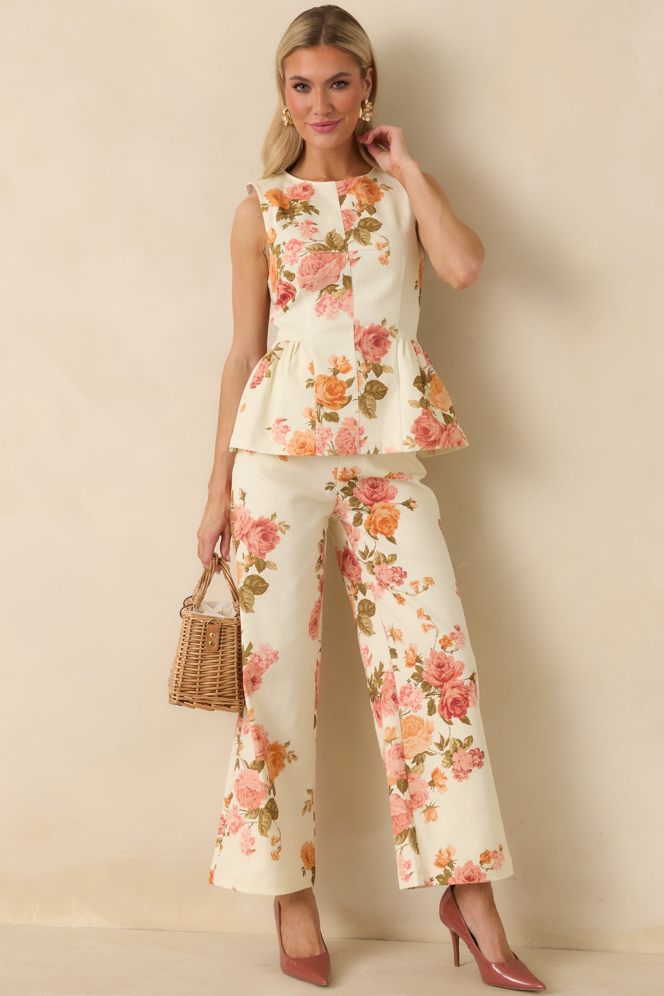 Pink floral cotton peplum top with a sleeveless design, round neckline, and structured bodice. Features a fitted waist and flared peplum hem for a polished, feminine silhouette.