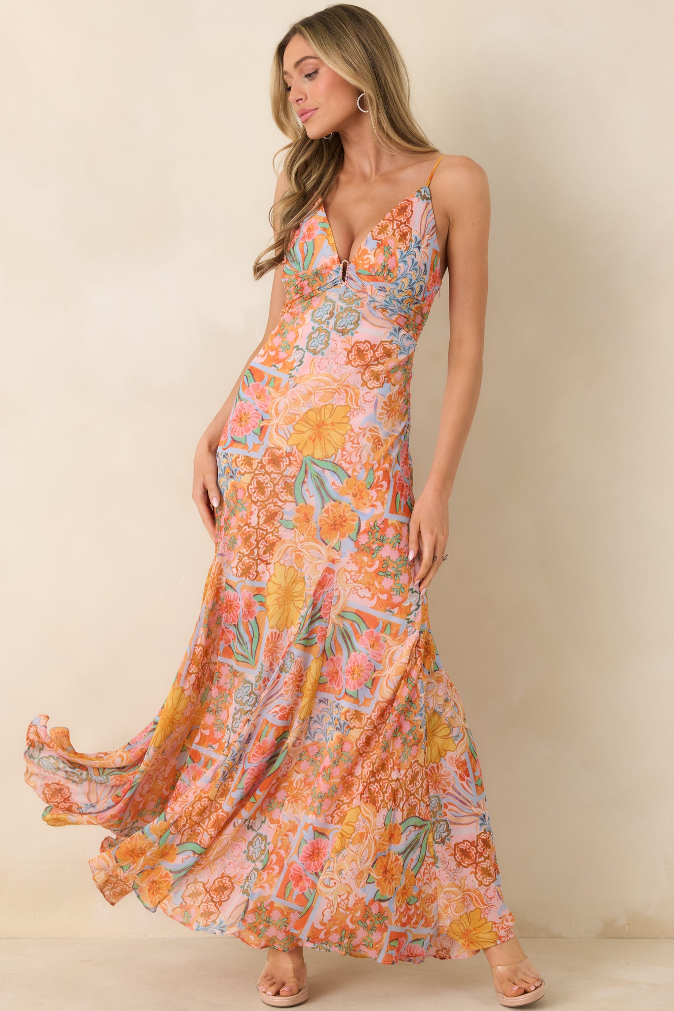 Pink floral maxi dress with a plunging V-neck, center ring accent, adjustable straps, smocked back, and a flowing skirt creating effortless movement.