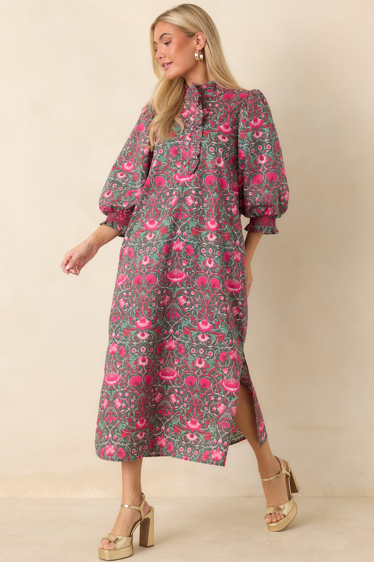 Pink floral midi dress with a straight skirt, side pockets, and a flowing drape.