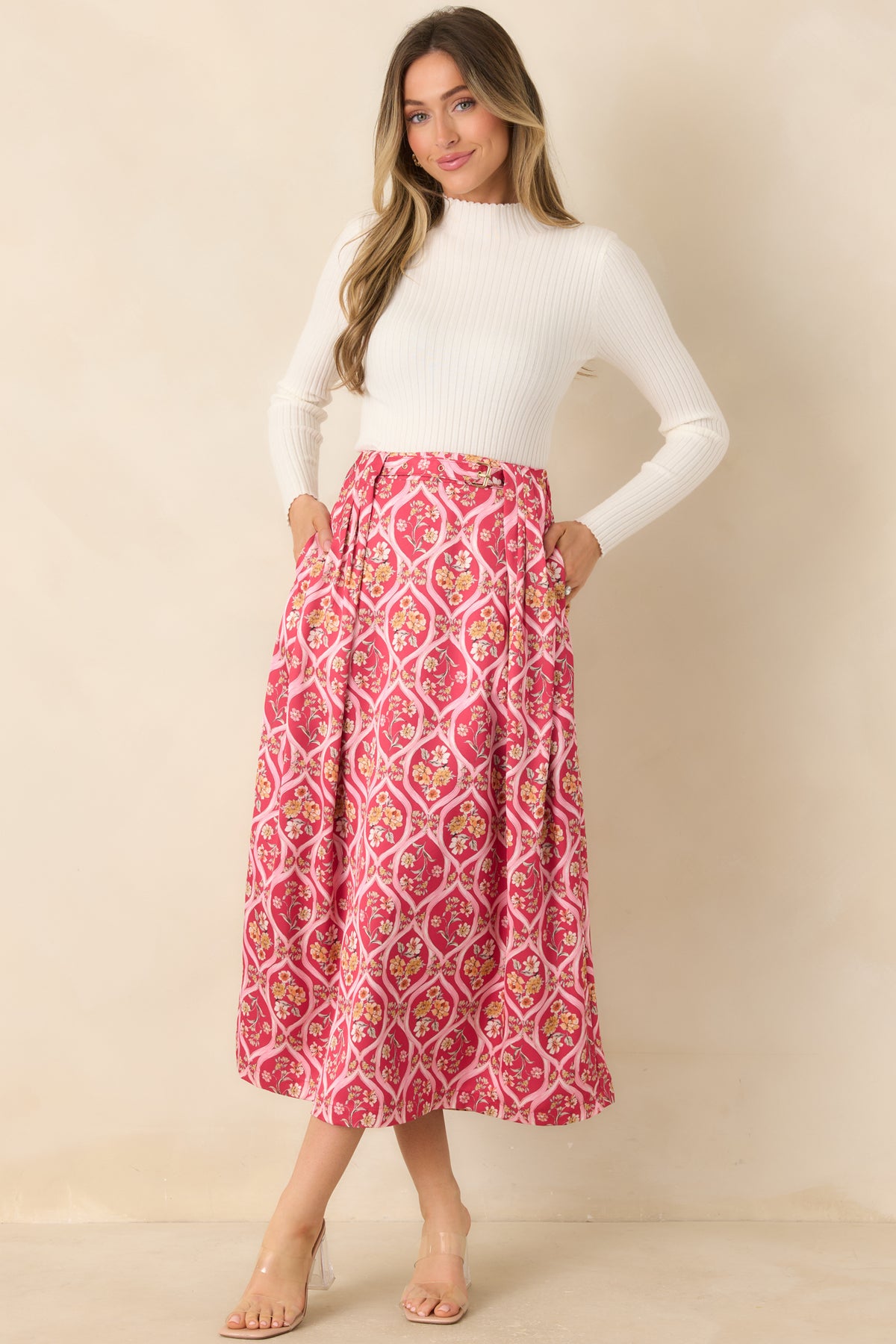 Floral pink midi skirt with an attached waist belt and a flared hem framed by colorful bouquets.