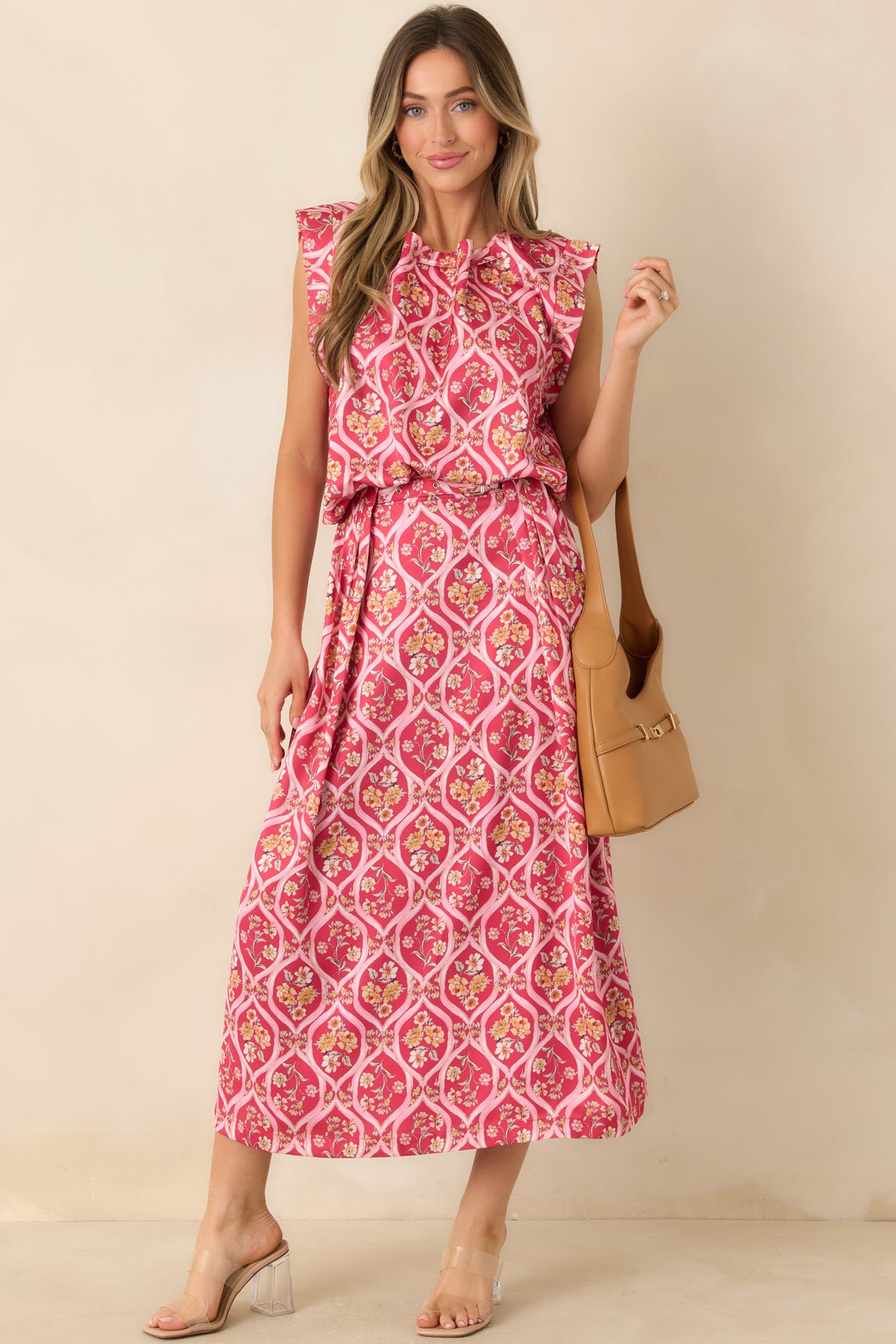 Pink floral midi skirt with peach, yellow, and ivory bouquets, front pleats, and an attached belt with a gold-tone buckle.