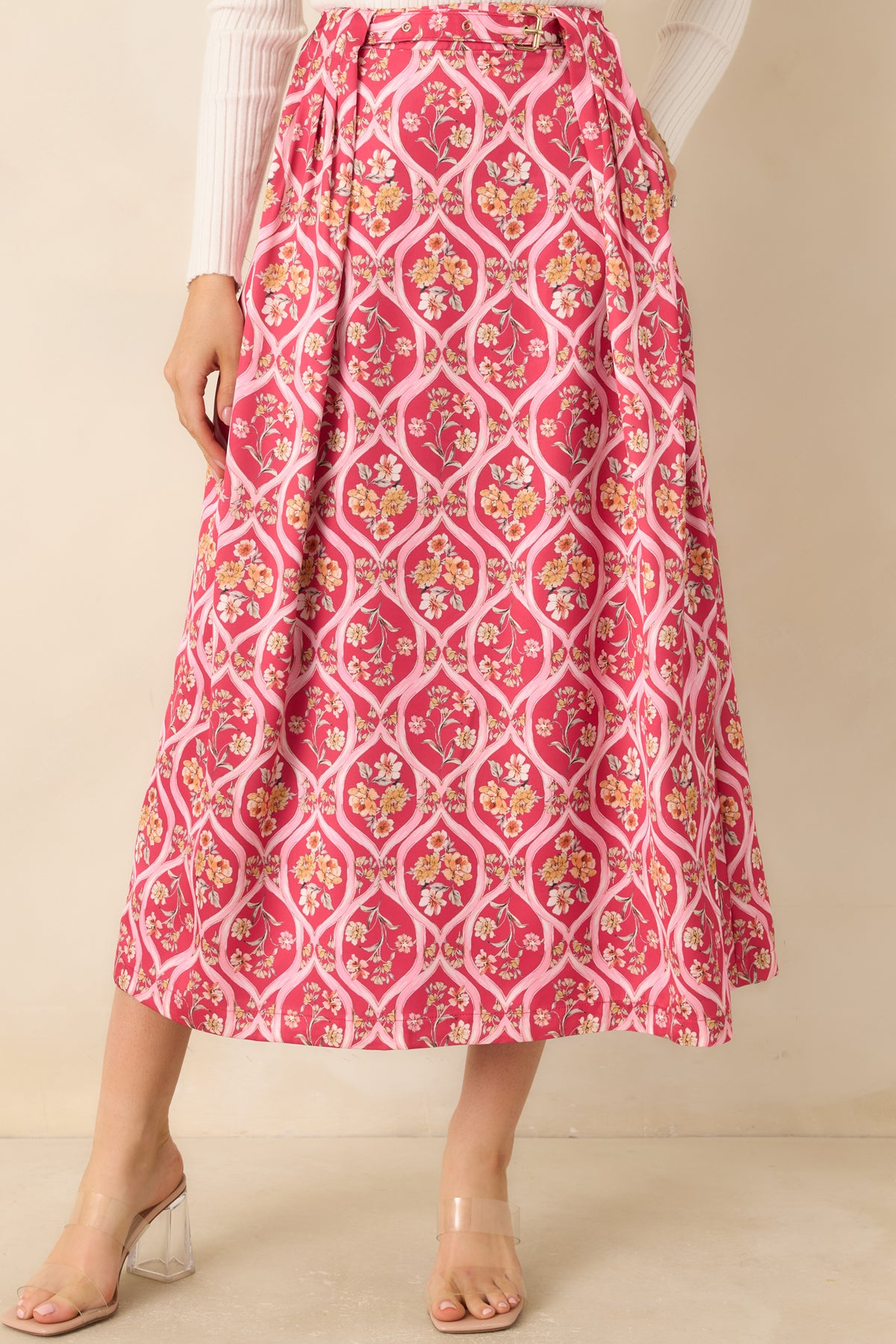 Pink floral skirt highlighting the attached belt, gold-tone buckle, and pleated waistband.