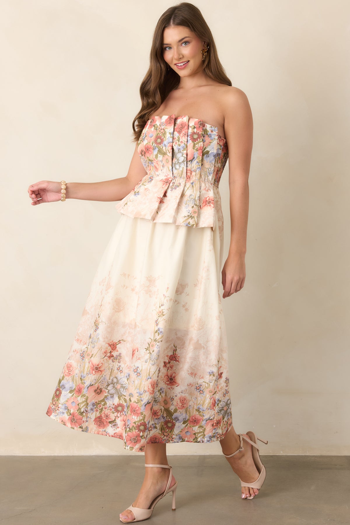 Pink multi-floral cotton midi dress featuring a strapless pleated bodice, elasticized waistband, and softly flowing skirt with convenient side pockets.