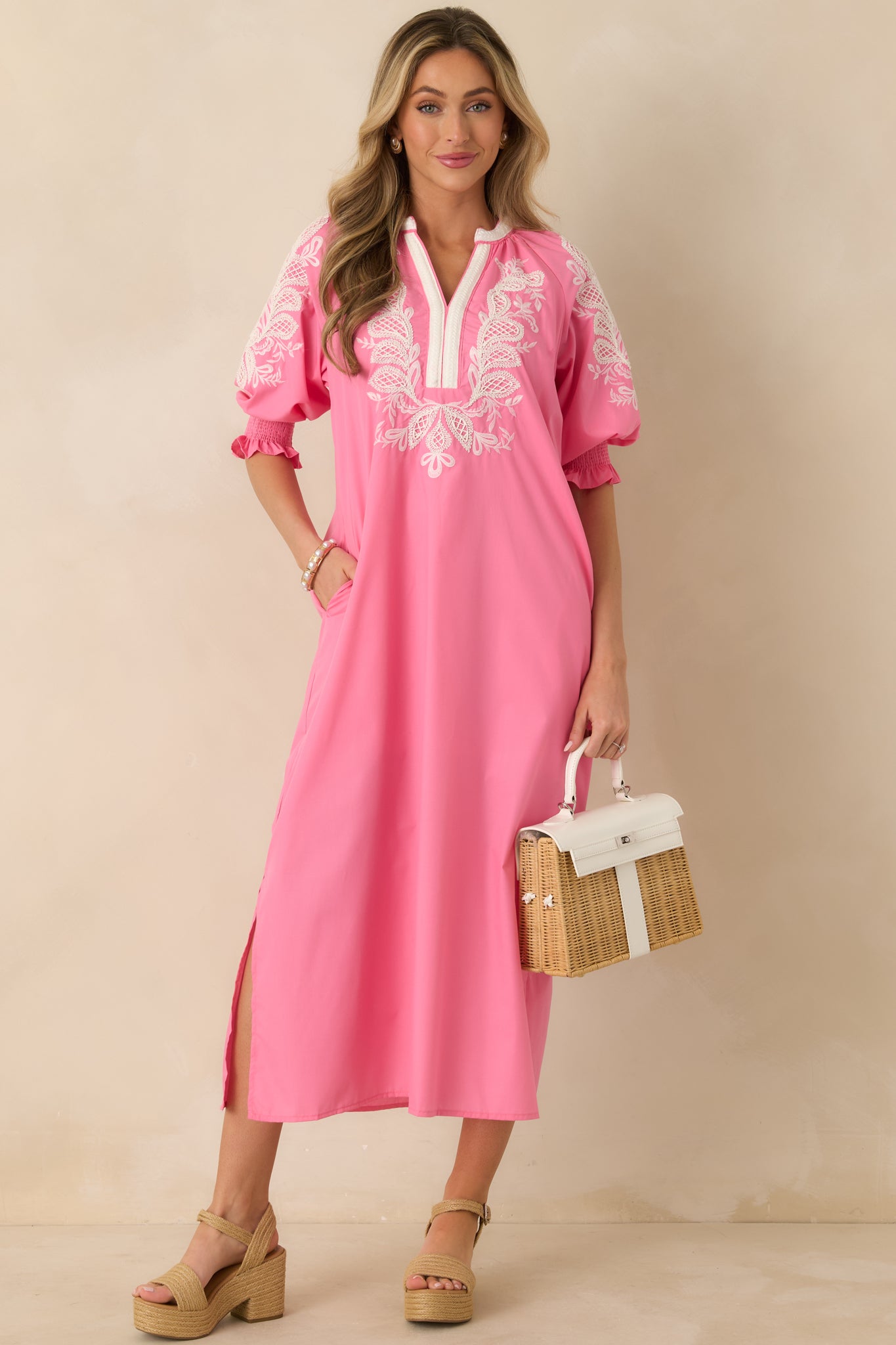 Pink maxi dress displayed front-facing, highlighting relaxed fit and intricate white embroidery across bodice and sleeves.
