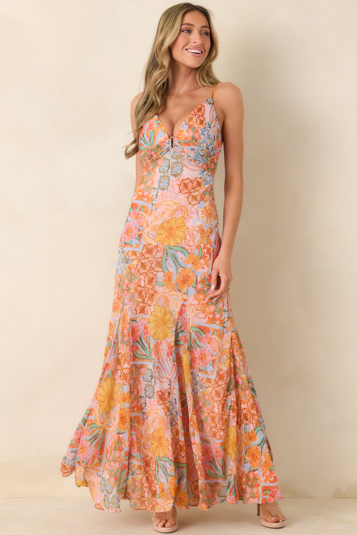 Lightweight pink maxi featuring multi floral pattern, smocked back panel, delicate ring accent at the V-neck, and a fluid, floor-grazing skirt.