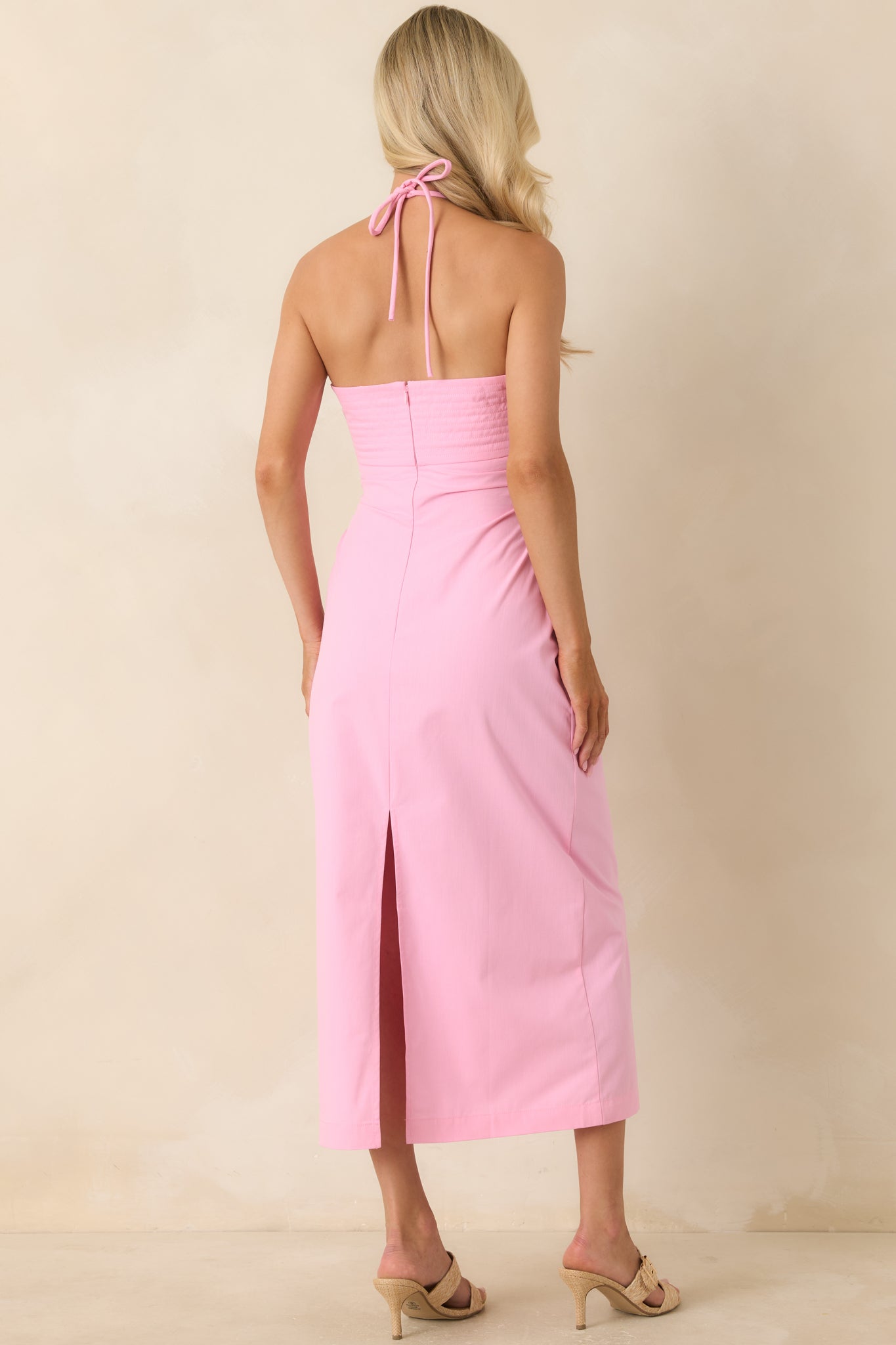 Back view of the pink midi dress featuring a concealed zipper and back slit detail.