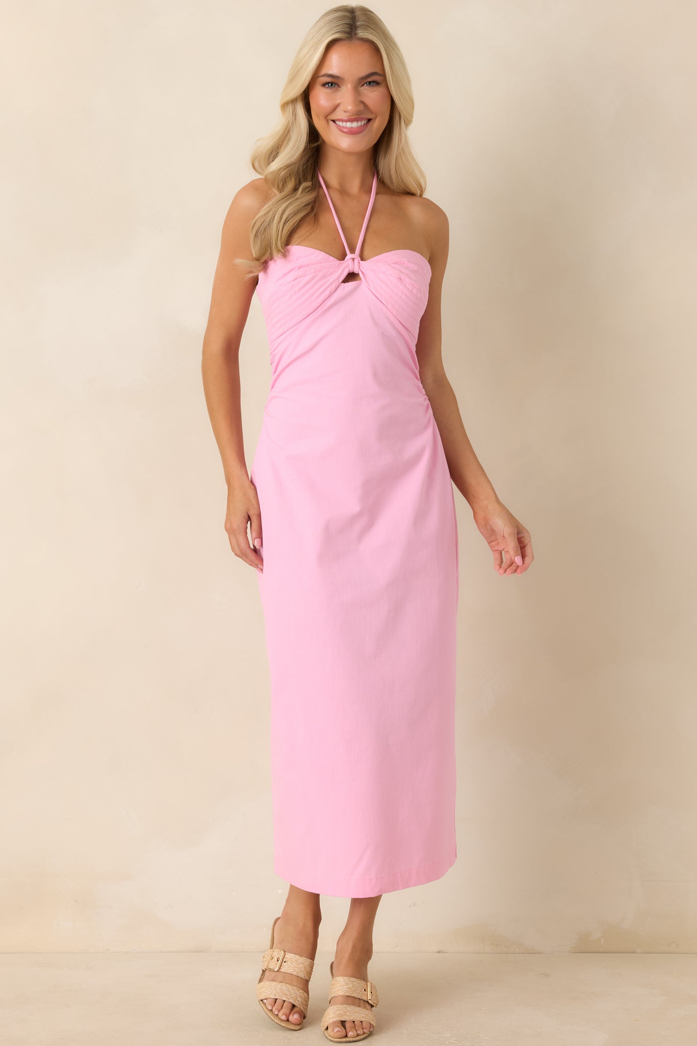Pink midi dress showcasing a front keyhole detail, adjustable tie closure, and sleek skirt shape.