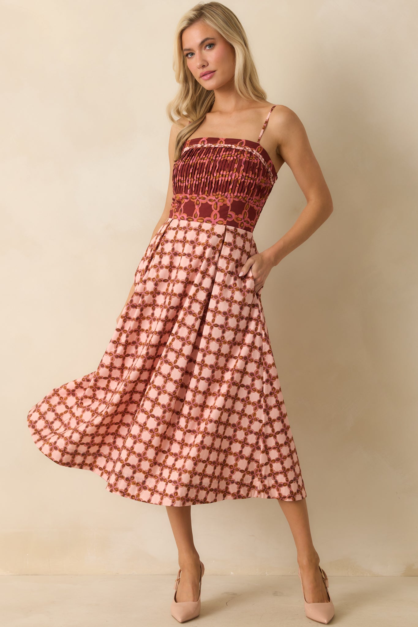 Pink midi dress with a multicolor geometric print and square neckline with braided trim.
