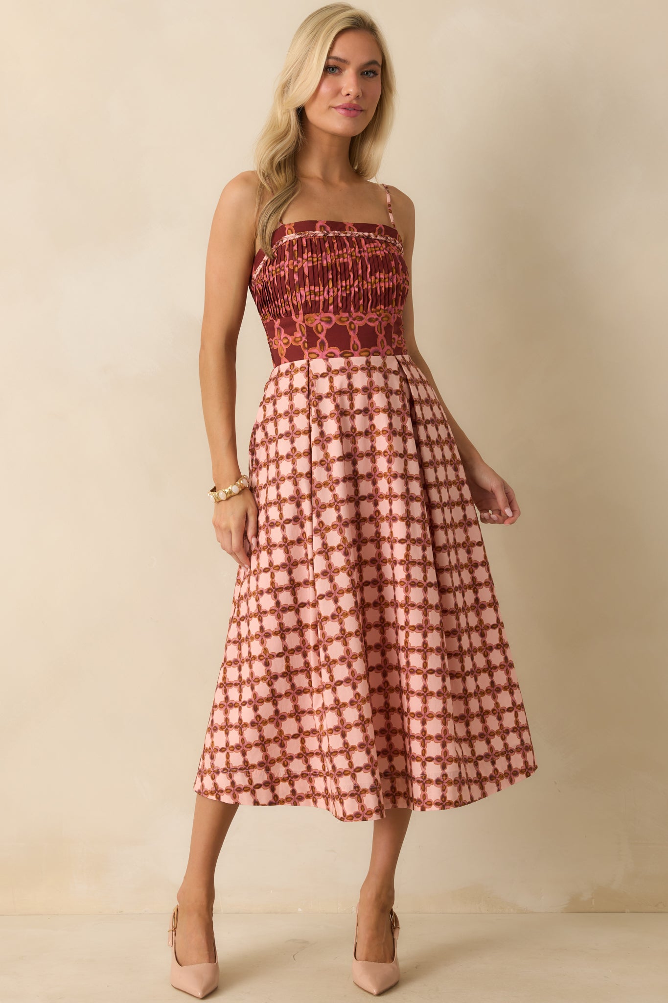 Pink midi dress with braided trim details and allover multicolor geometric pattern.