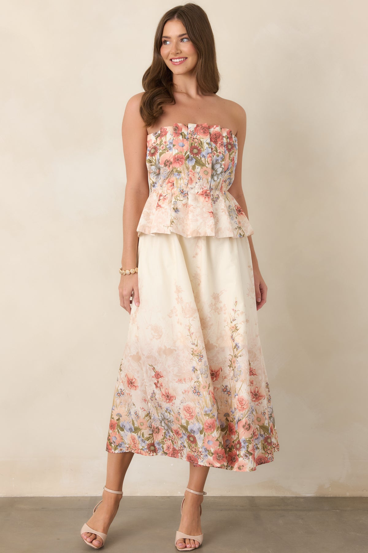 Cotton midi dress defined by its pink multi-floral print, strapless pleated bodice, comfortable elastic waist, and practical side pockets.