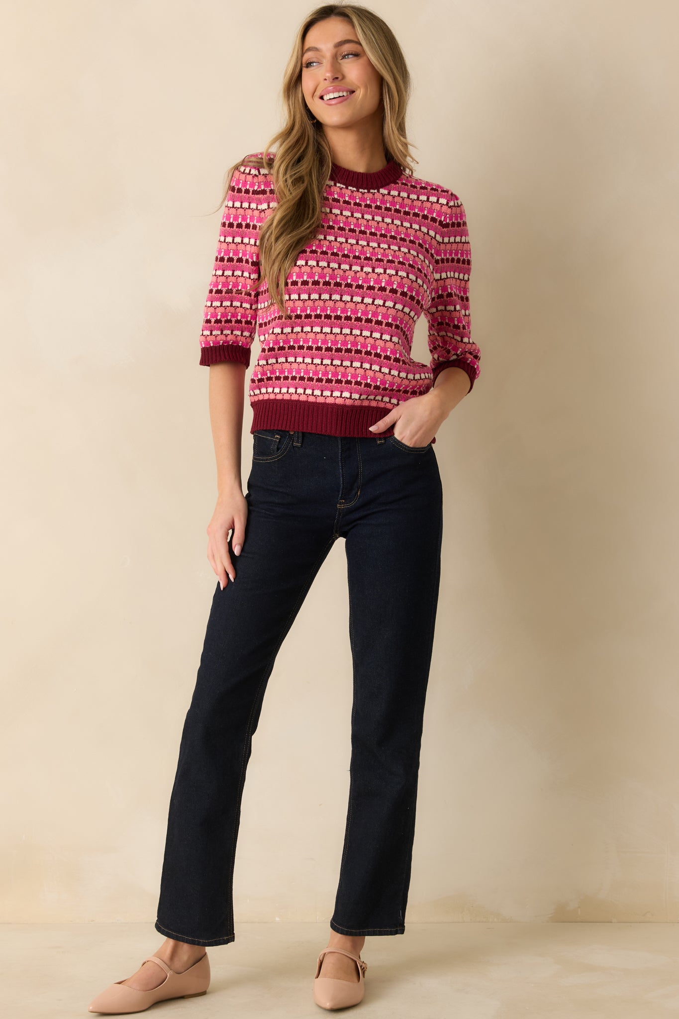 The sweater displays its pink multi knit with vibrant stripes, 3/4 sleeves, and classic crew neckline.