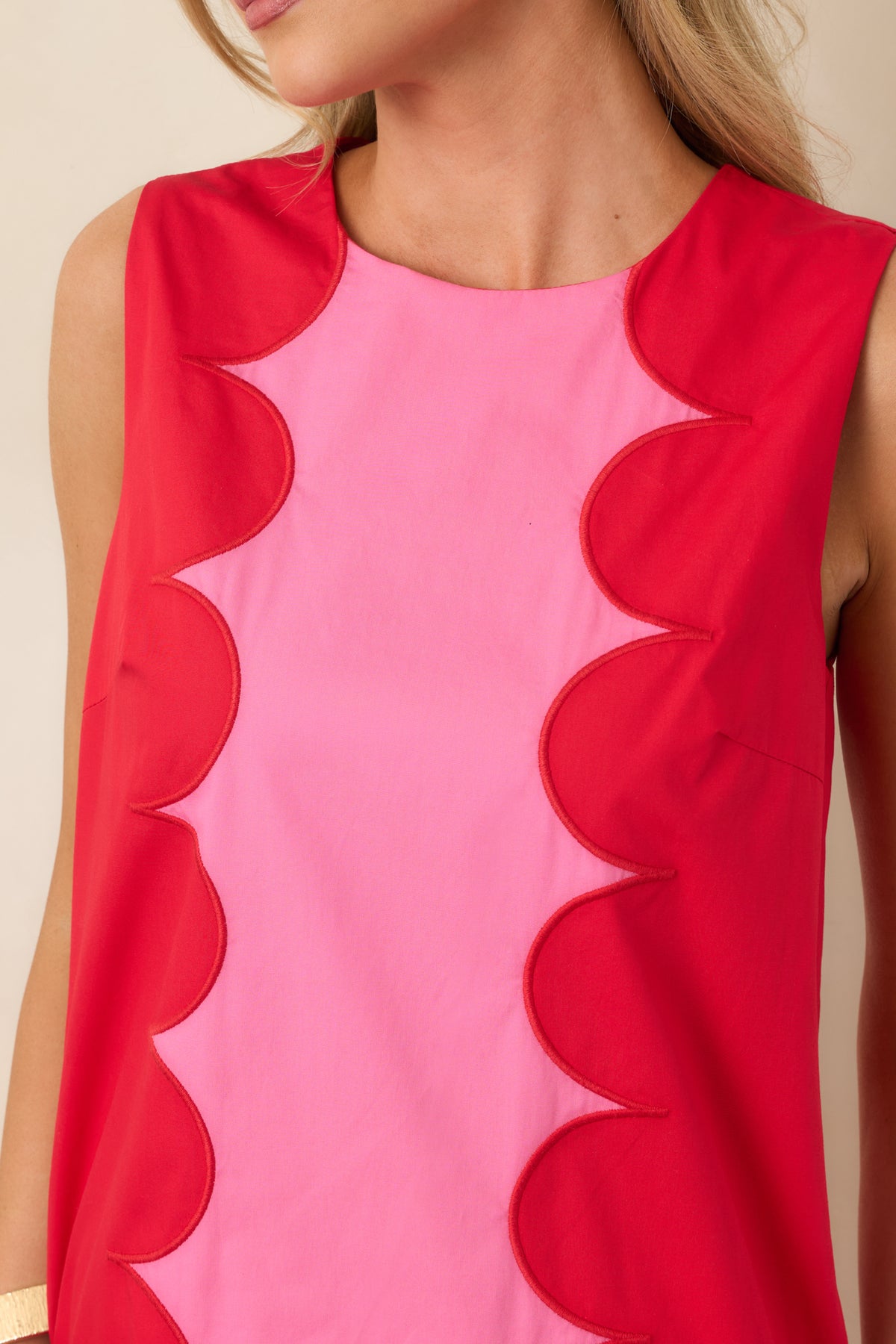 Close-up of the vibrant pink fabric and red scalloped contrast trim, showcasing the bold color combination and polished construction.
