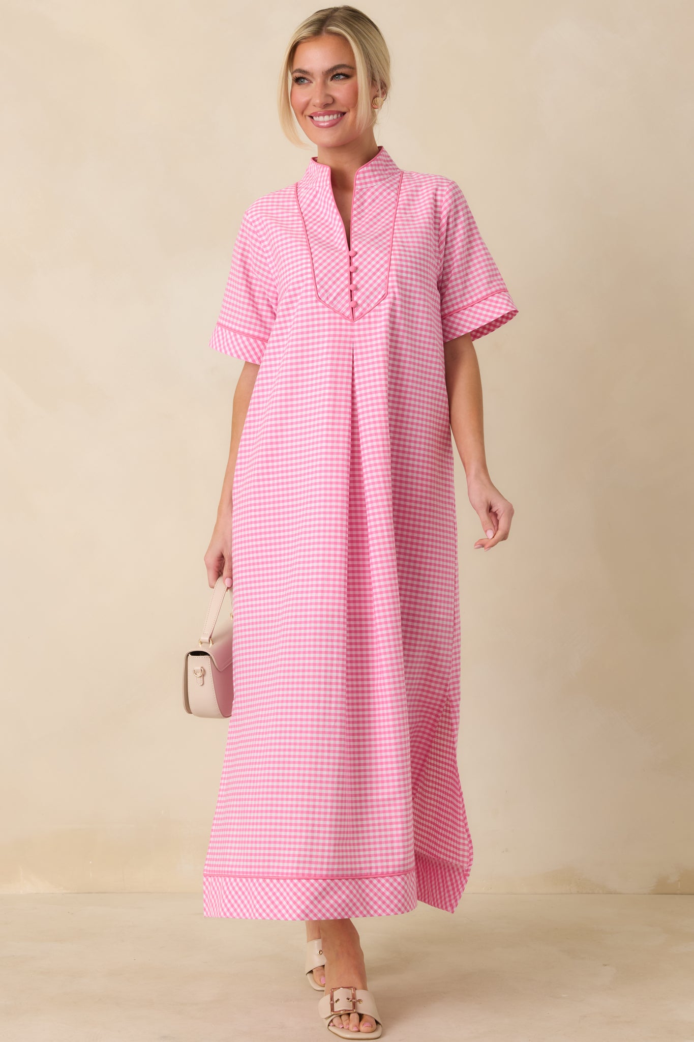 Pink short sleeve maxi dress shown from the front, featuring V-neckline with contrasting trim and flowing skirt.