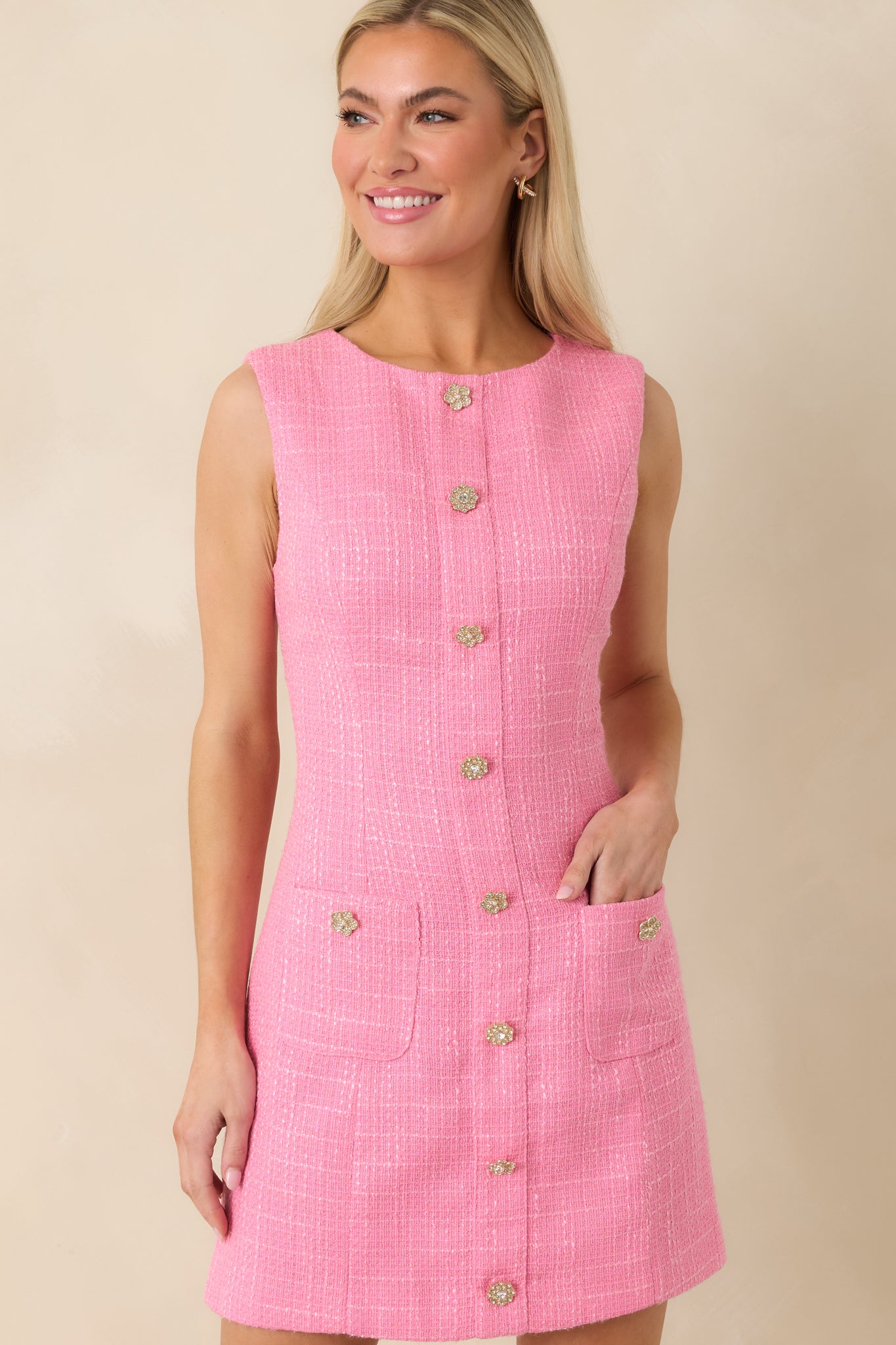 Pink sleeveless tweed dress focusing on the tailored shift shape and front pocket accents.