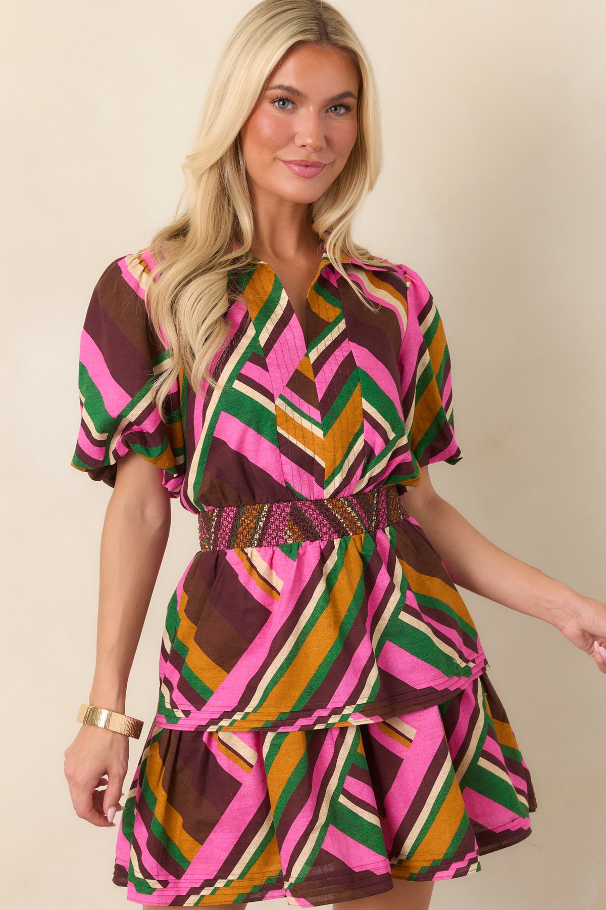 Detailed view of the embroidered wide smocked waist against the mixed-direction pink and multicolored stripe print.