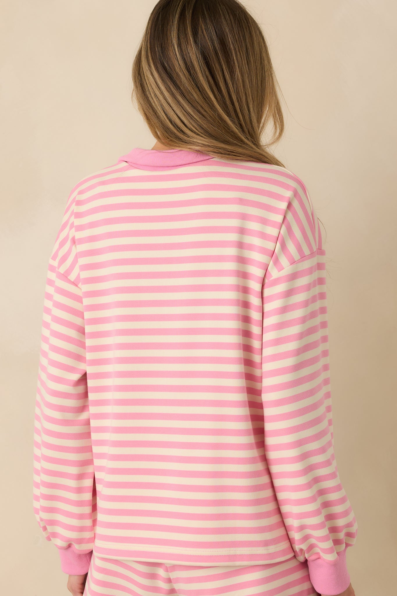 Pink striped lounge top displaying the relaxed silhouette from the rear with a smooth knit finish and ribbed hem.